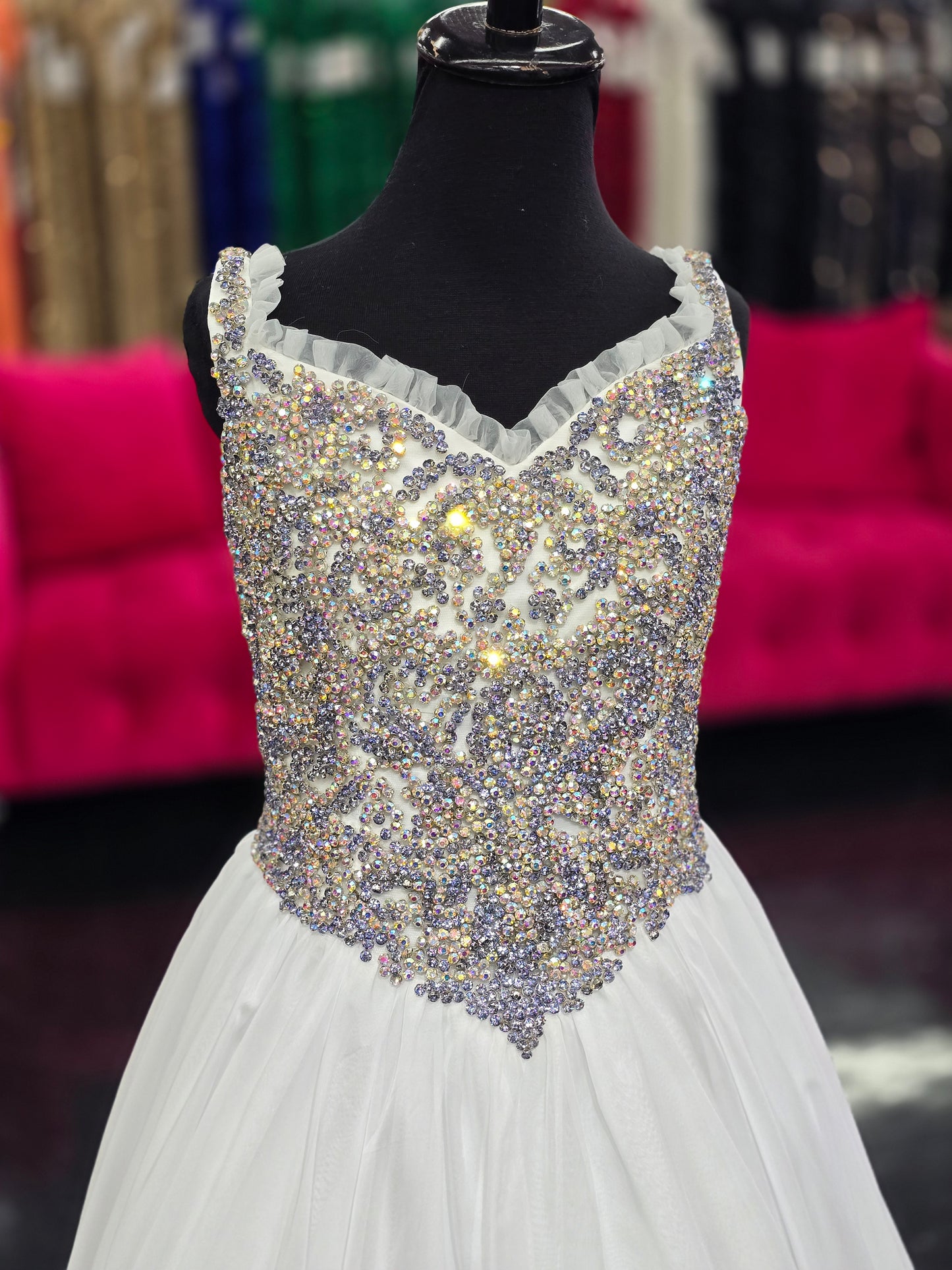 Experience the luxurious elegance of the Samantha Blake 1127 Pageant Dress. Made with soft, lightweight chiffon, this A-line ballgown will have your little girl feeling like a true princess. The crystal embellished bodice and ruffle trim neckline add a touch of sparkle and charm. Perfect for any pageant or special occasion.