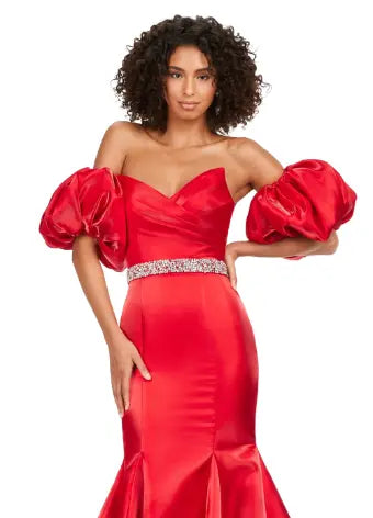 Expertly crafted by Ashley Lauren, this 11419 Long Prom Dress boasts a stunning mermaid silhouette with a strapless design and luxurious satin fabric. The oversized puff sleeves add a bold and elegant touch, making you stand out at any formal event or pageant. Elevate your look with this timeless and sophisticated gown.  Voluminous puff sleeves and a classic sweetheart neckline frame this stunning gown. With its mermaid fit and jeweled belt, this gown is a dream come true!