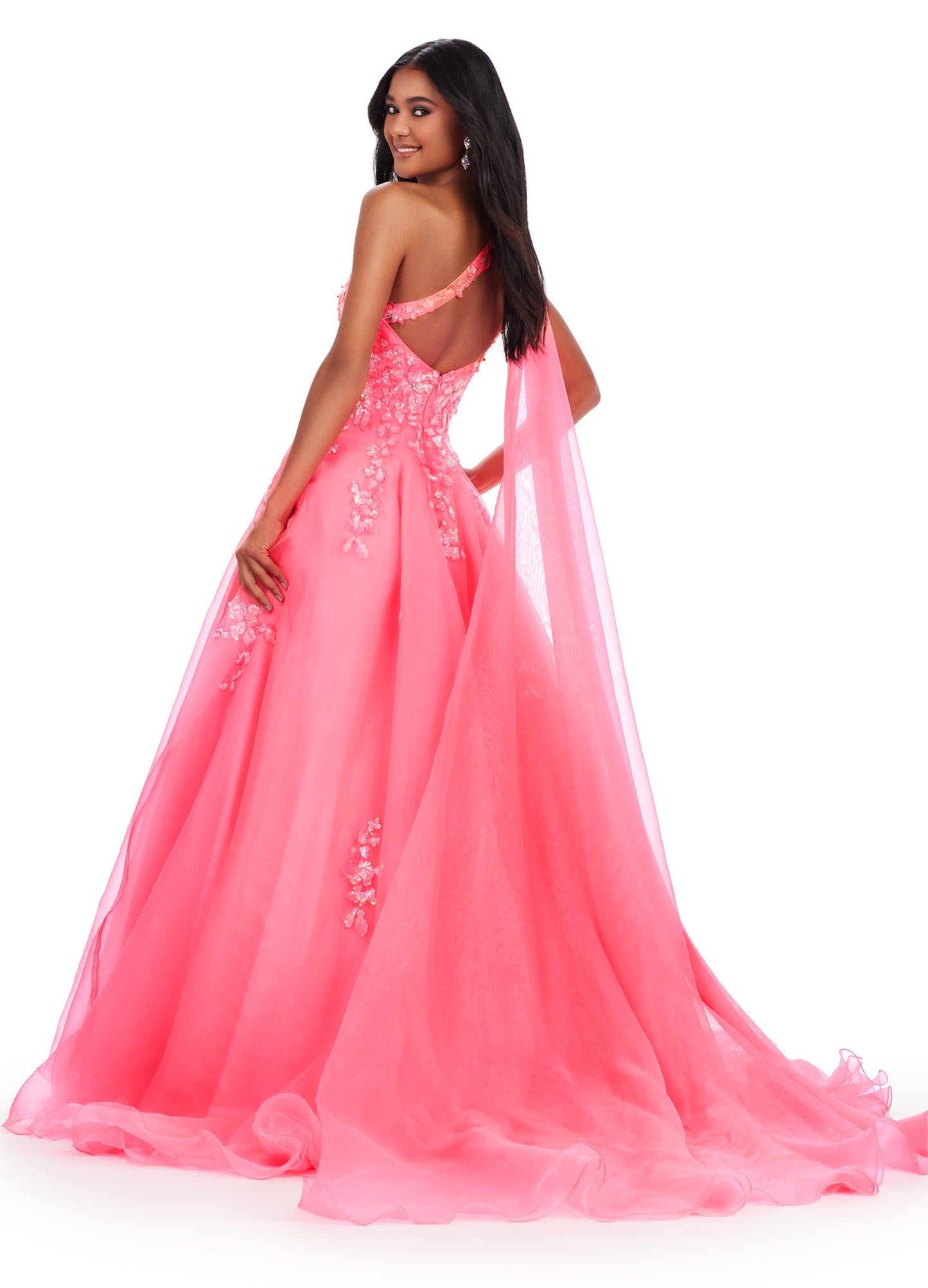 This Ashley Lauren 11573 Long Prom Dress exudes elegance with its one shoulder design and sequin applique. Crafted from high-quality organza, this gown will make you stand out at any formal event or pageant. Its classic silhouette and sparkling details are perfect for making a statement. This romantic one shoulder organza ball gown features intricate sequin applique. The look is complete with an open back and a one shoulder cape.