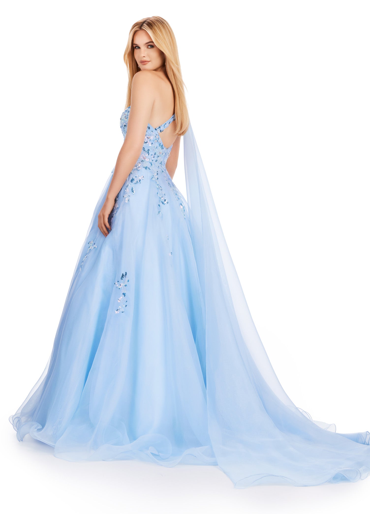 This Ashley Lauren 11573 Long Prom Dress exudes elegance with its one shoulder design and sequin applique. Crafted from high-quality organza, this gown will make you stand out at any formal event or pageant. Its classic silhouette and sparkling details are perfect for making a statement. This romantic one shoulder organza ball gown features intricate sequin applique. The look is complete with an open back and a one shoulder cape.