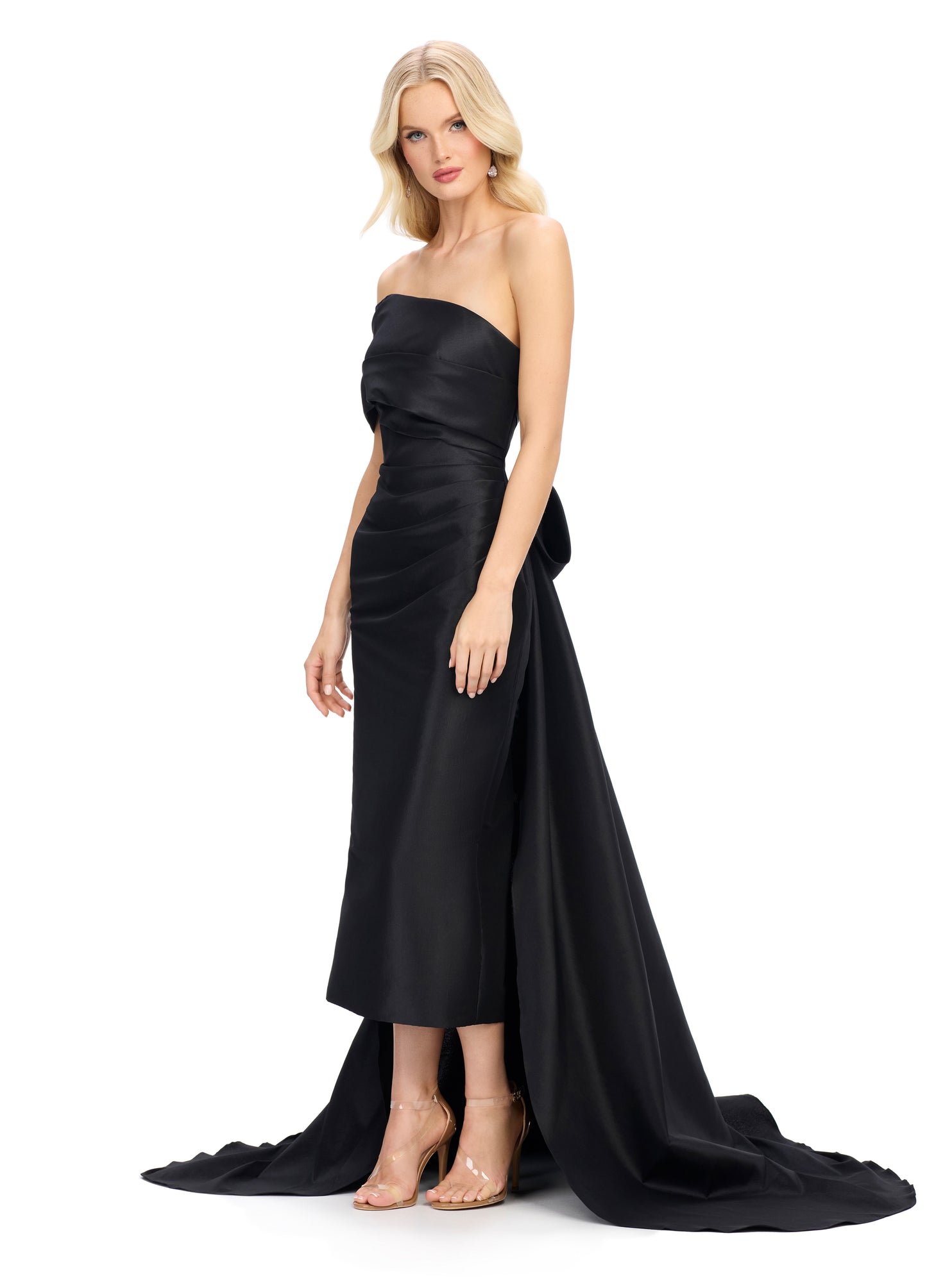 This Ashley Lauren 11727 one shoulder evening gown is a stunning choice for your next special event. The wide wrap strap and sheath design create a flattering silhouette, while the half bow in the back adds a touch of elegance. The overskirt with train adds drama and movement to the dress. Expertly designed for a sophisticated and memorable look.