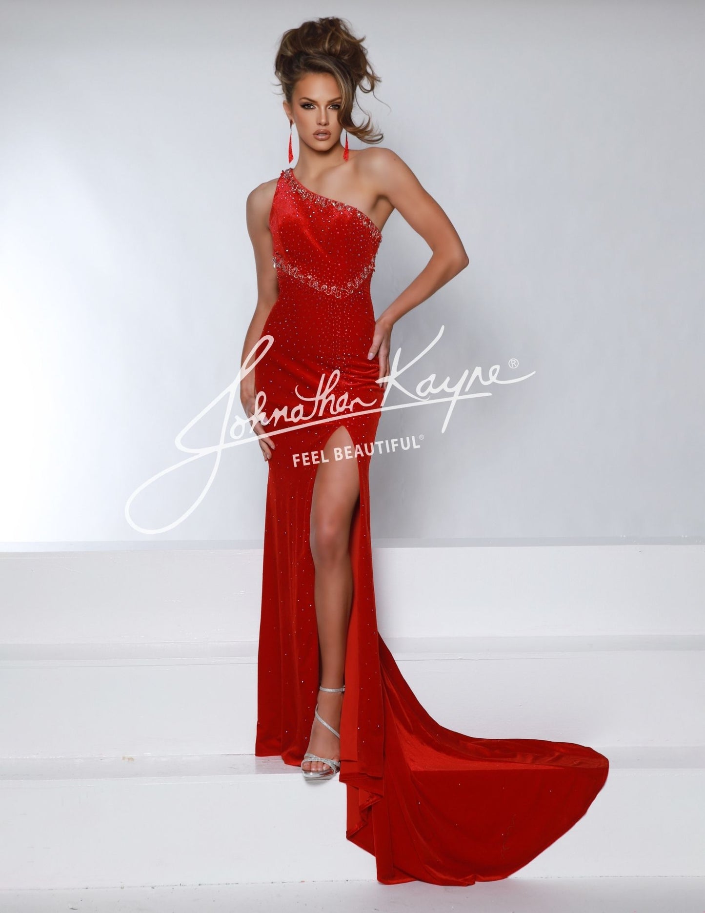 This Johnathan Kayne 2963 Velvet One Shoulder Pageant Dress features a stylish cape, one shoulder design, and a cutout back with a slit. The velvet material adds a touch of luxury, making it perfect for formal events. Be the star of the show in this unique and elegant gown.