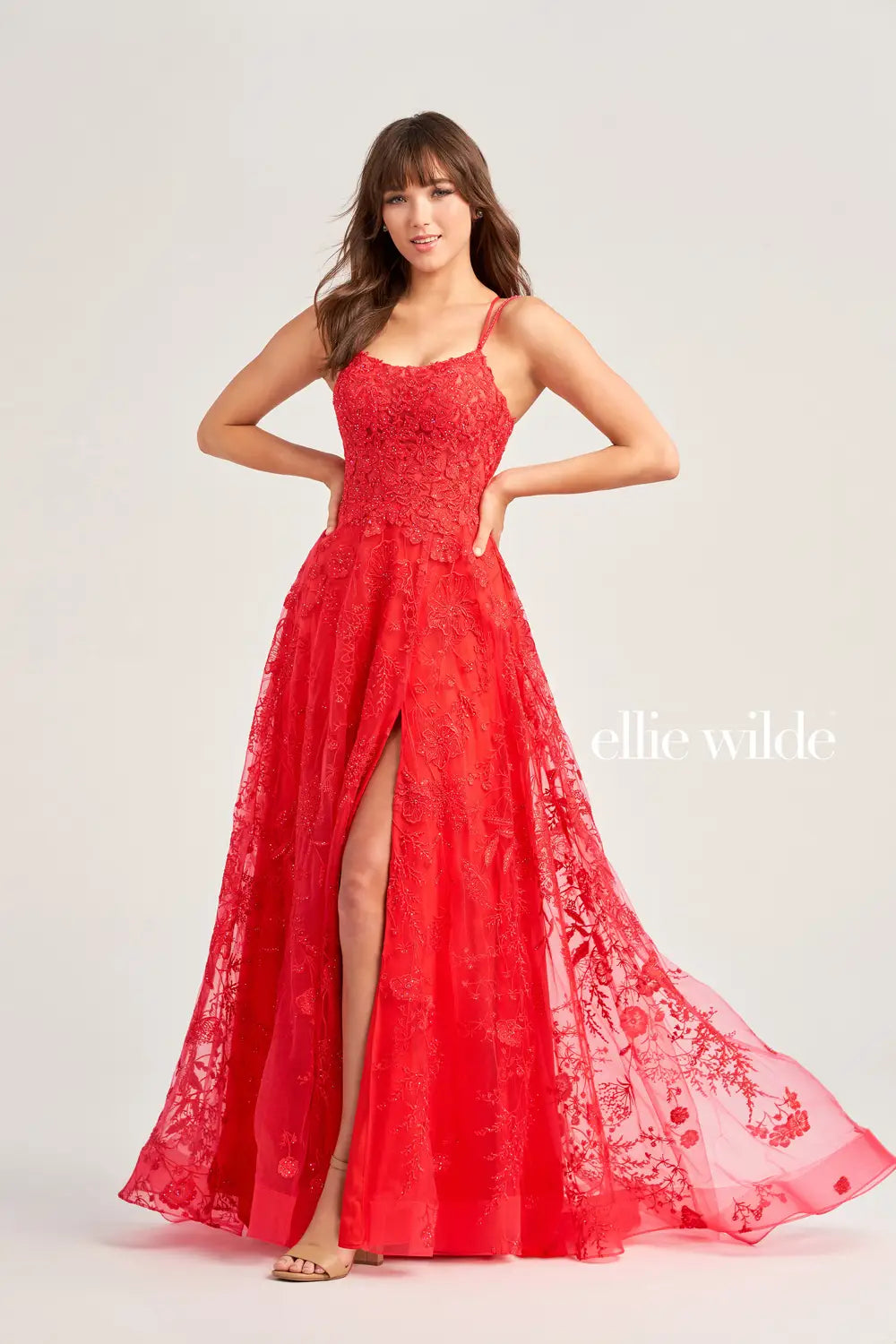 This Ellie Wilde EW35012 Formal Gown is the perfect blend of style and comfort. Crafted with beautiful embroidered tulle, lace, and stone accents, this dress features a long length, scoop neckline, and A-line silhouette. Practical and eye-catching, this gown has pockets, a high slit, and a lace-up back, all draped on a flattering natural waistline. A perfect pick to shine in style at your next event.  COLOR: MAGENTA, EMERALD, STRAWBERRY, BLUEBELL SIZE: 00 - 24