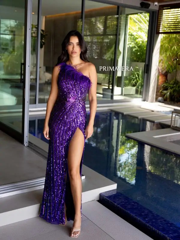 Elevate your style with the Primavera Couture 4112 long prom dress. This stunning gown features a one shoulder design with feathers, a high slit, and sequin details for a glamorous touch. Perfect for formal events, pageants, and more. Make a statement with this fitted and elegant gown.