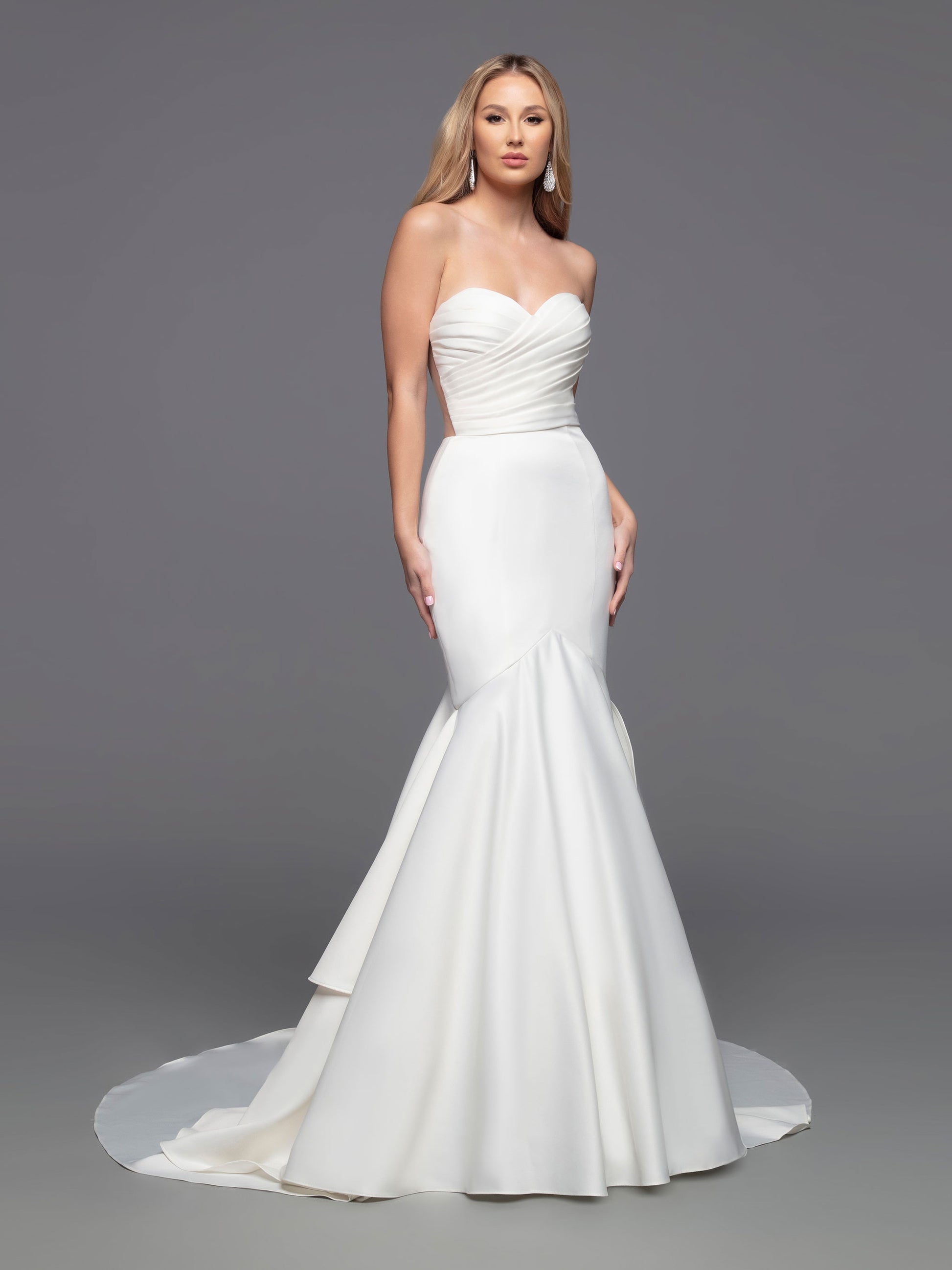 The Davinci Bridal 50808 Long fitted Strapless satin mermaid wedding dress boasts a beautiful modern design with a traditional flair. Its fit & flare silhouette is enhanced by an opaque ruched front bodice and a romantic ruffled mermaid skirt with a sheer back bodice. This stylish design is finished with covered buttons and a tiered back skirt, culminating in a chapel train.  Sizes: 2-20  Colors: Ivory, White