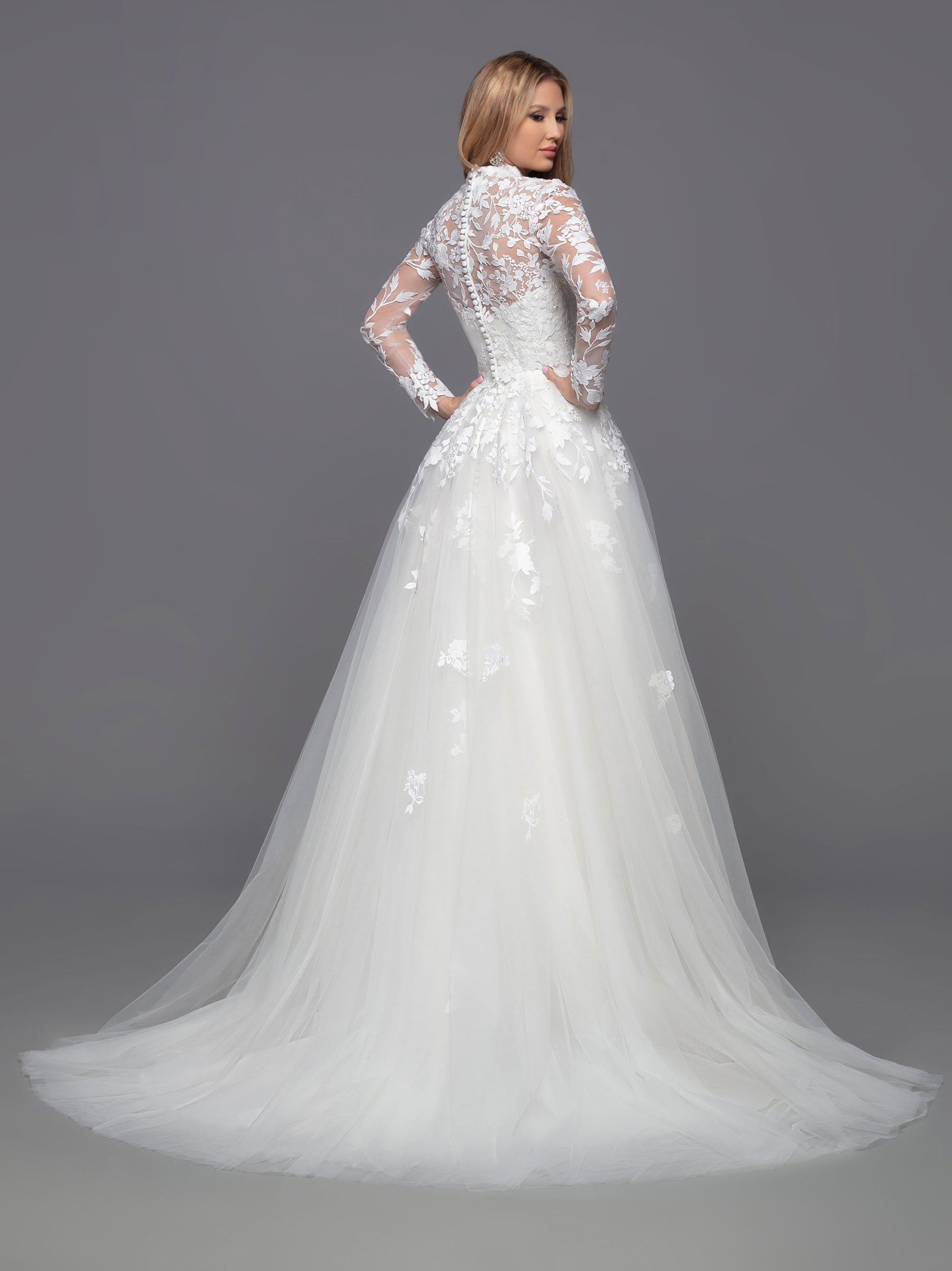 Look stunning on your big day with Davinci Bridal 50813. This beautiful tulle ballgown features a long a-line silhouette with a detachable lace long sleeve high neck jacket. Perfect for modest brides and cold weather weddings, the sheer lace bodice, back, and full-length sleeves create a breathtaking look. Lace accent at the waist of the layered skirt, and a chapel train, completes this stunning ensemble.  Sizes: 2-20  Colors: Ivory