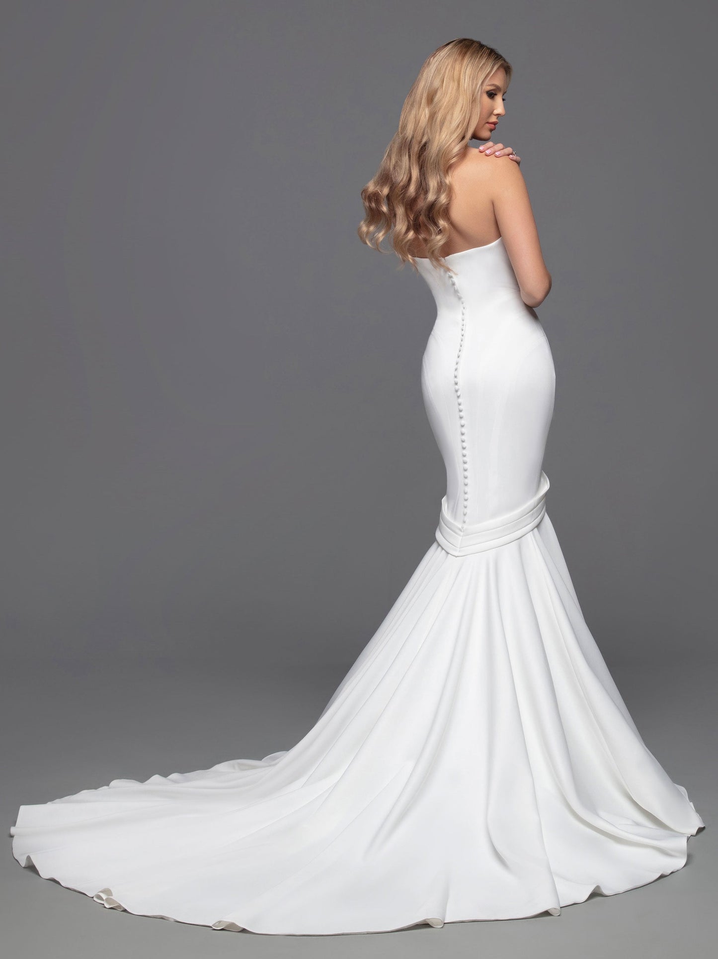 Davinci Bridal Gown 50816 size 12 Ivory Long Fitted Mermaid Wedding Dress Pointed strapless Experience an unforgettable wedding day with this luxurious bridal gown from Davinci. Crafted from alluring ivory fabric, this fit-and-flare mermaid gown is perfected with a strapless, straight-across neckline, a modest silhouette, and an open back with interesting button details and a zipper fastening. The chapel train adds a truly elegant touch.  Size: 12  Color: Ivory 