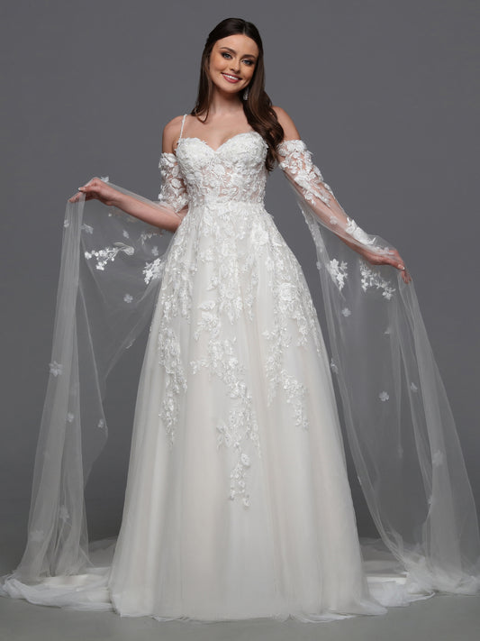 Indulge in luxury and grace with the Davinci Bridal 50834 3D Lace A Line Wedding Dress. Adorned with a detachable cape sleeves and sheer beading, this gown exudes elegance and sophistication. The 3D lace detail adds a touch of artistry, making you feel like a walking masterpiece on your special day. One of our most unique detachable styles, this wedding dress has lace gauntlets with veil wings that add drama to your portraits and your walk down the aisle.