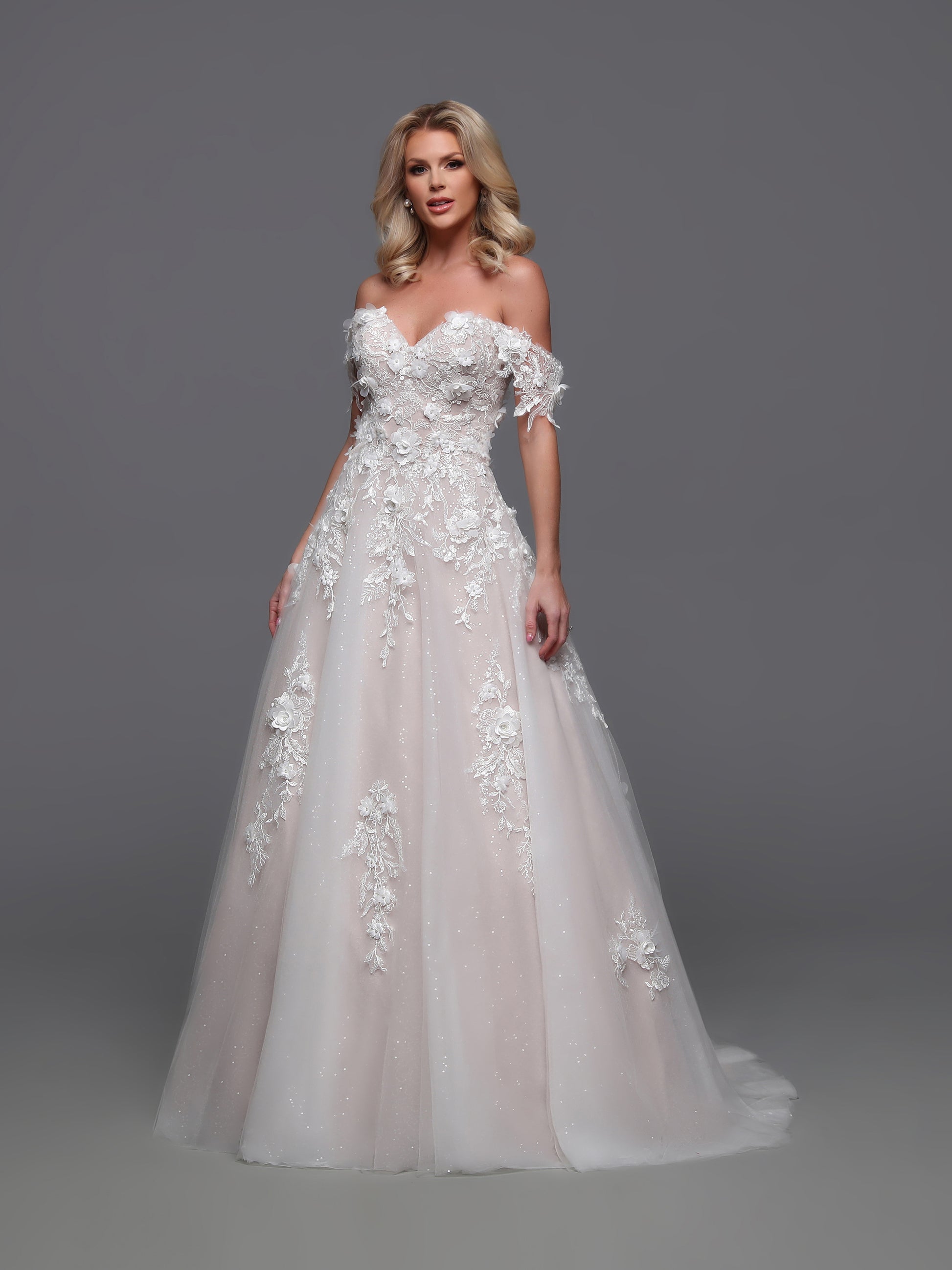 Elevate your elegance with the Davinci 50883 wedding dress. Beautifully designed with a detachable off shoulder sleeve and corset bodice, this A line lace gown exudes luxury. The sequin shimmer ballgown adds a touch of glamour, creating a one-of-a-kind bridal look that will leave a lasting impression.