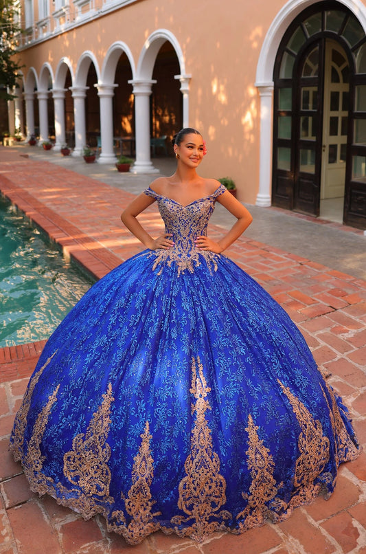 This Amarra 54324 Quinceanera Dress boasts a glittering hooded cape and off-the-shoulder corset, perfect for making a grand entrance at any party or ball. The exquisite train and bow detail add an extra touch of elegance to this stunning gown. Elevate your style with this eye-catching dress.