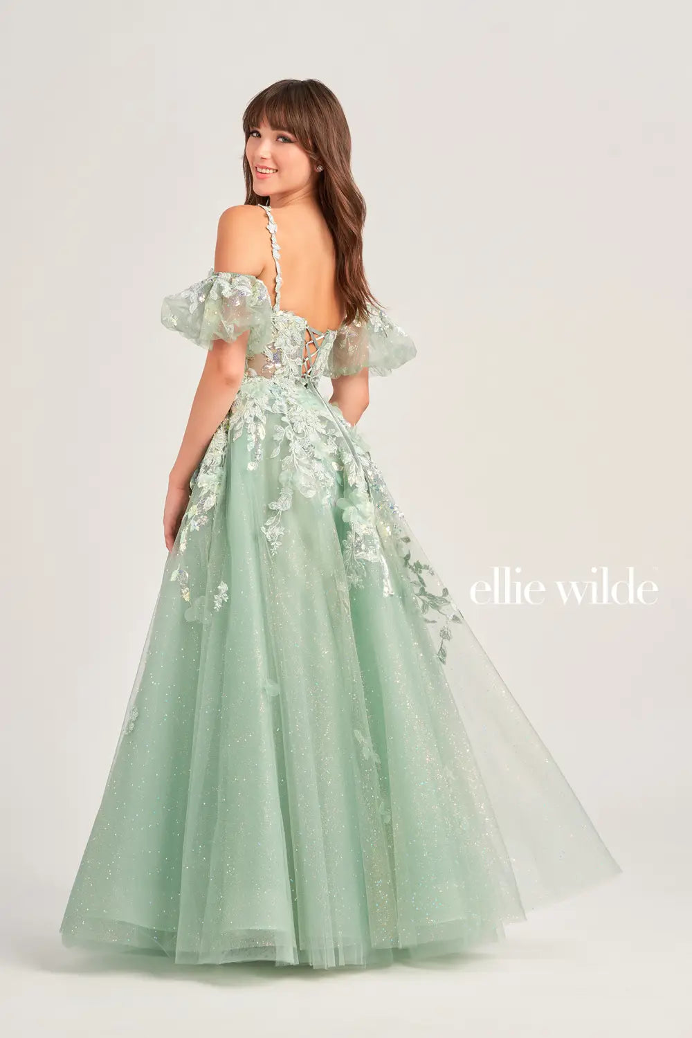 The Ellie Wilde EW35205 Prom Dress combines sheer sequin lace with a corset top and A-line silhouette, creating a stunning and shimmering gown. The puff sleeves add a touch of glamour, making this dress perfect for any prom or formal event. Pockets  Sizes: 00-20  Colors: Sage, Ice Blue