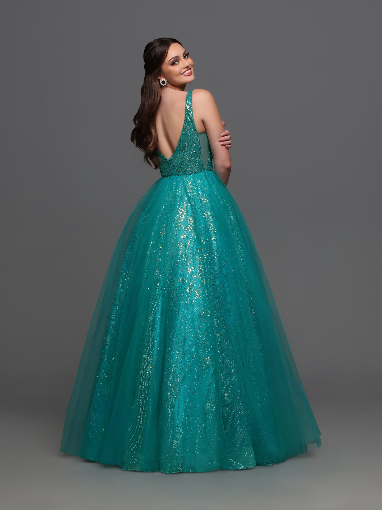 The Candice Wang 72336 Prom Dress is both chic and glamorous! Featuring a sheer glitter A-line design with a striking V-neckline and a stylish slit, this dress adds a touch of shimmer to your formal event. Perfect for making a statement and standing out in the crowd.  Sizes: 0-20  Colors: Lavender, Teal