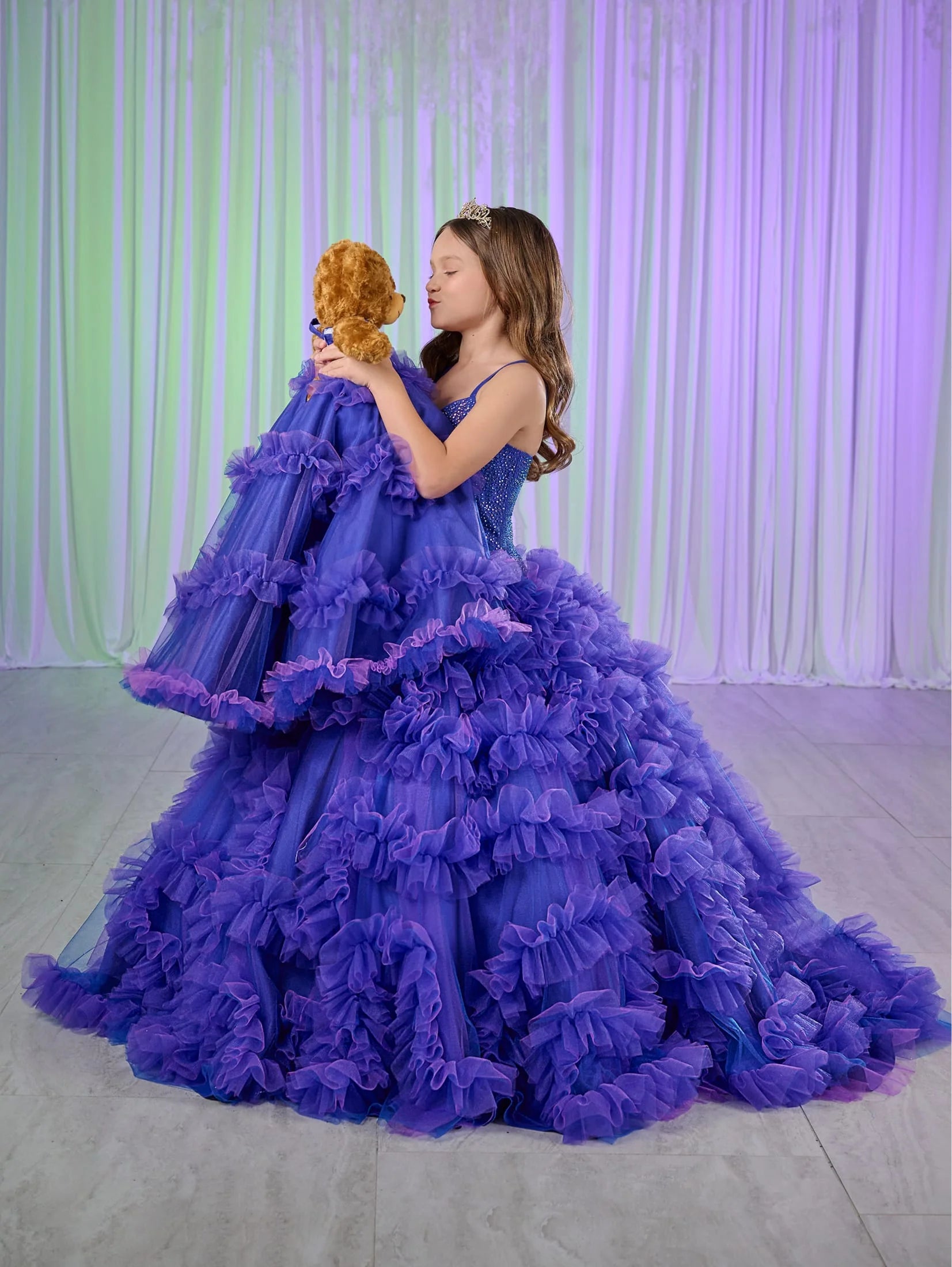 Rule the pageant stage with the Tiffany Princess 80023MQ Girls Ruffle Dress. This stunning ball gown features a crystal-embellished corset bodice and flowing ruffled skirt, perfect for making a grand entrance. The elegant design will have your little girl feeling like royalty, while the comfortable fit allows for graceful movement