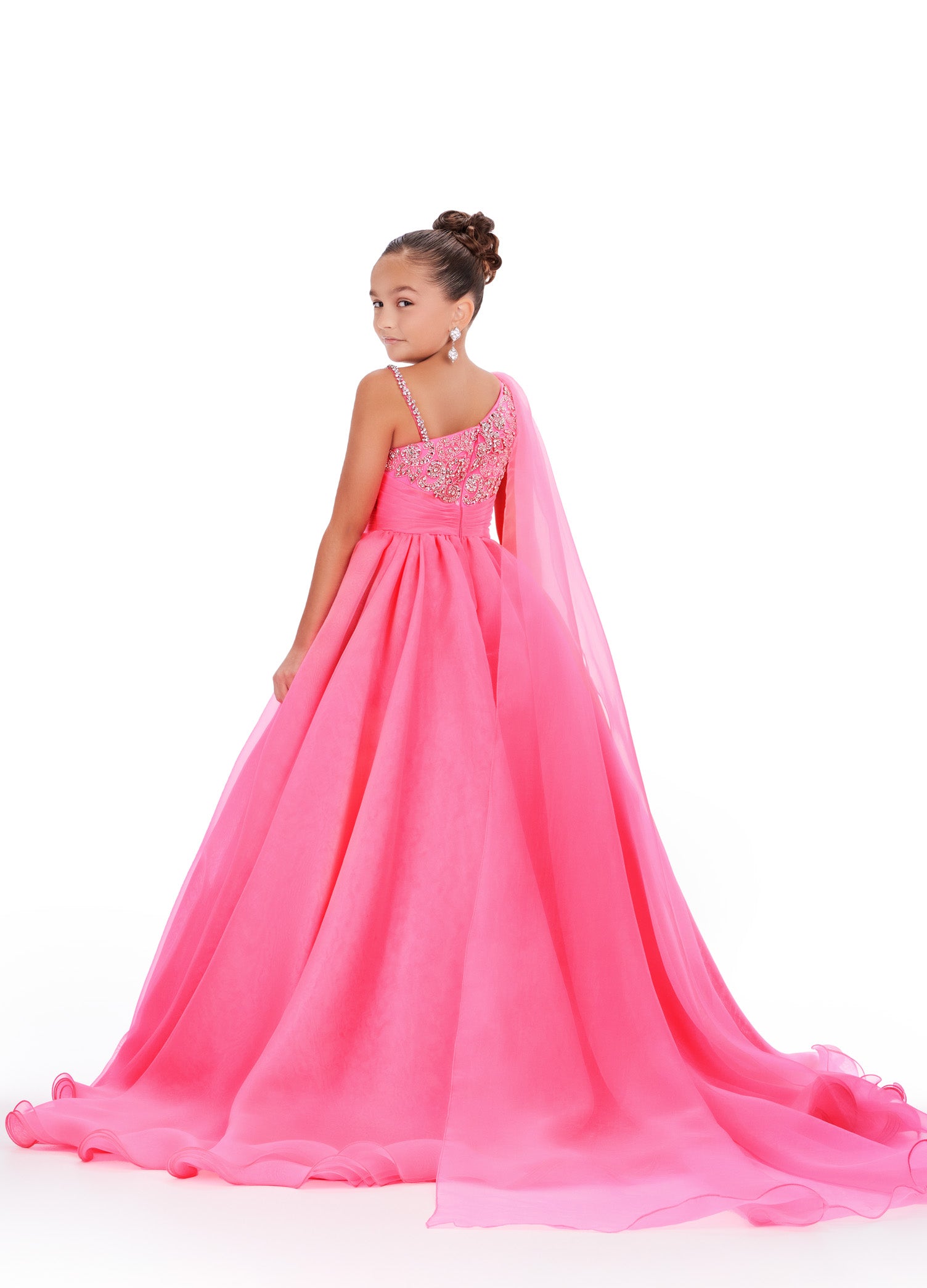 This Ashley Lauren Kids 8212 one-shoulder girls' pageant dress is both elegant and fun. With a cape design and crystal embellishments, this A-line ball gown is perfect for any pageant or special occasion. Look and feel like a princess in this stunning dress. This gorgeous organza ball gown is meant for a future queen! Featuring a stunning beaded bustier and one shoulder cape, this gown is sure to stun!