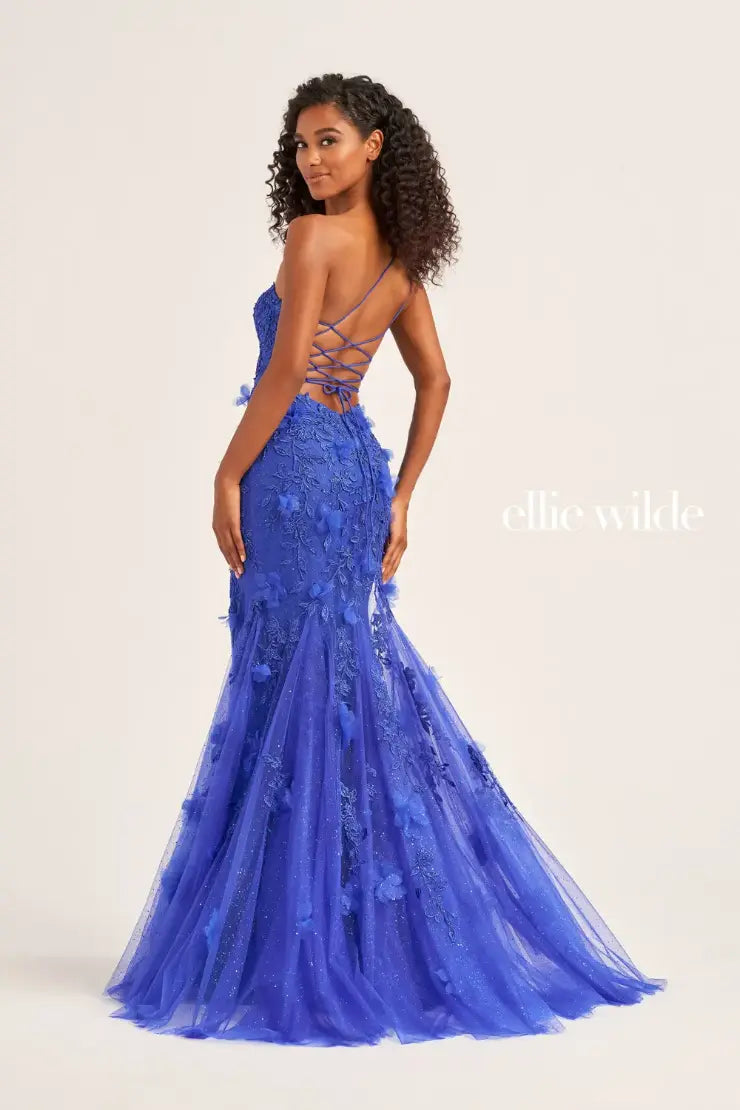 This Ellie Wilde EW35049 prom dress is designed with sheer shimmer lace, a one shoulder sheer lace corset bodice, and a mermaid silhouette with a backless design and a thigh-high slit. Perfect for prom or any formal occasion, this gown offers a touch of elegance and glamour, sure to turn heads and make a lasting impression. backless lace up  Sizes: 00-16  Colors: Emerald, Dark Red, Royal Blue