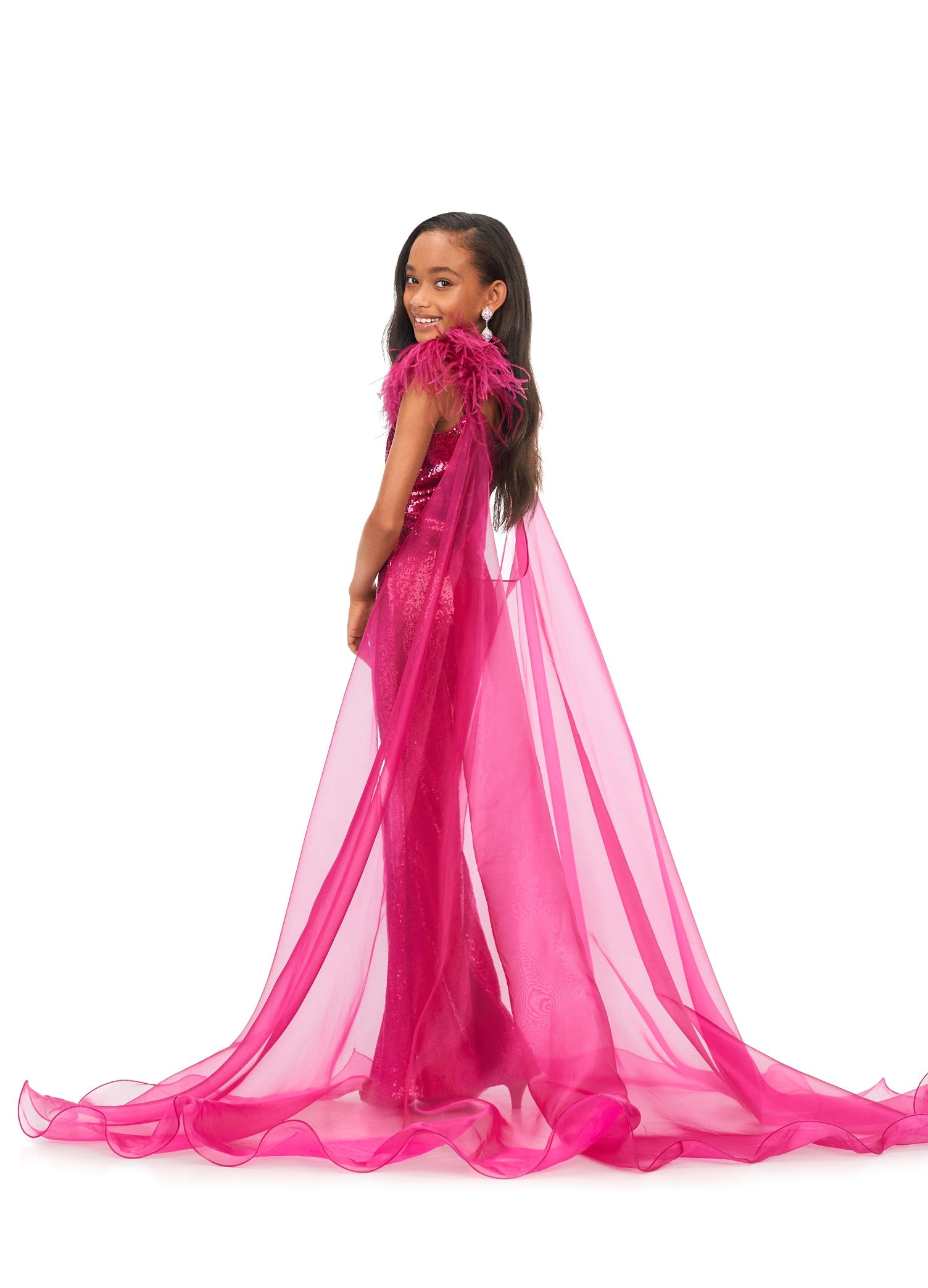 Ashley Lauren Kids 8174 Girls Sequin Jumpsuit with Organza Cape  Bring the drama in this kids sequin jumpsuit featuring a v-neckline. The look is complelted with an off the shoulder feather strap and organza cape.