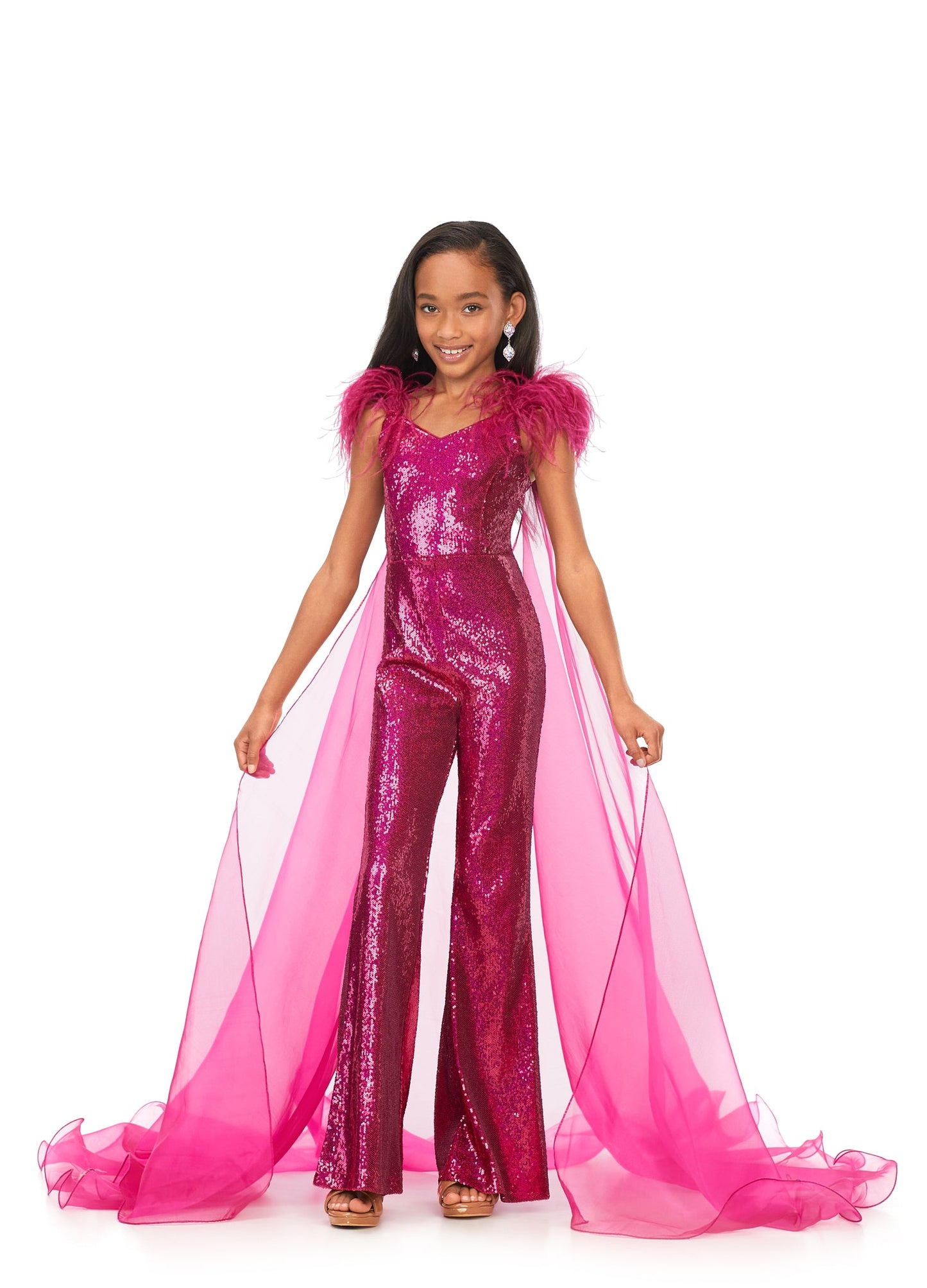 Ashley Lauren Kids 8174 Girls Sequin Jumpsuit with Organza Cape  Bring the drama in this kids sequin jumpsuit featuring a v-neckline. The look is complelted with an off the shoulder feather strap and organza cape.