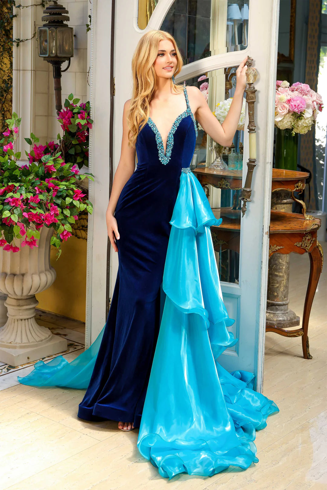 Expertly crafted and designed by Ava Presley 39556 Long fitted Velvet Formal Dress is a must-have for any special occasion. With a stunning V neck and crystal detailing, this gown exudes elegance and sophistication. The formal Side overskirt and&nbsp; slit add a touch of drama, making you the belle of the ball.