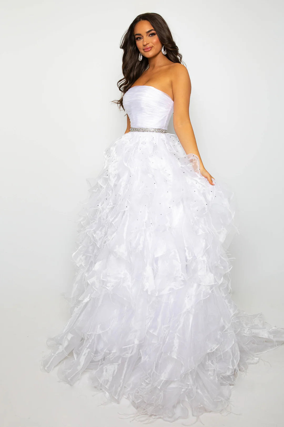 Elevate your formal attire with the Ava Presley 39555 Ballgown. This luxurious dress boasts a long feather ruffle and a strapless design, exuding elegance and style. Perfect for prom or pageants, this exclusive dress will make you feel like a true fashion icon. Float down the runway in this ethereal strapless ball gown, featuring a ruched bodice and cascading ruffle skirt that brings volume and drama. The cinched waist, adorned with a sparkling belt, adds a touch of glamour to this stunning look. Perfect fo