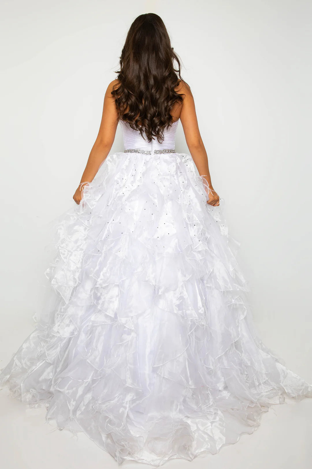 Elevate your formal attire with the Ava Presley 39555 Ballgown. This luxurious dress boasts a long feather ruffle and a strapless design, exuding elegance and style. Perfect for prom or pageants, this exclusive dress will make you feel like a true fashion icon. Float down the runway in this ethereal strapless ball gown, featuring a ruched bodice and cascading ruffle skirt that brings volume and drama. The cinched waist, adorned with a sparkling belt, adds a touch of glamour to this stunning look. Perfect fo