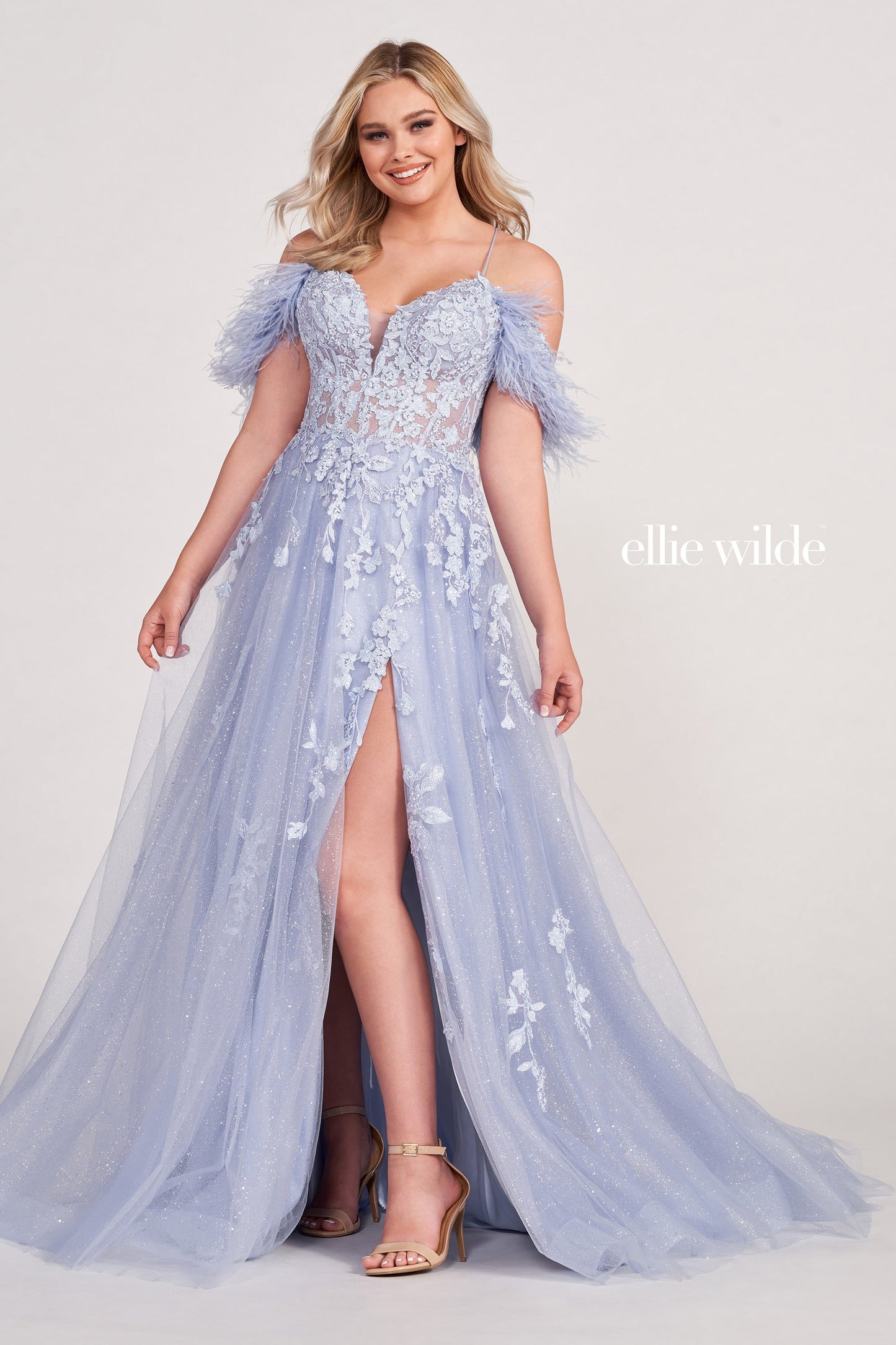 The Ellie Wilde EW34066 is a stunning A-line gown with a sheer sequin corset and feather off-the-shoulder detail. Boasting a dazzling shimmer finish and dramatic slit, this exquisite dress will make you the belle of the ball.  Sizes: 00-16  Colors: ORANGE, RED, PERIWINKLE, IRIS