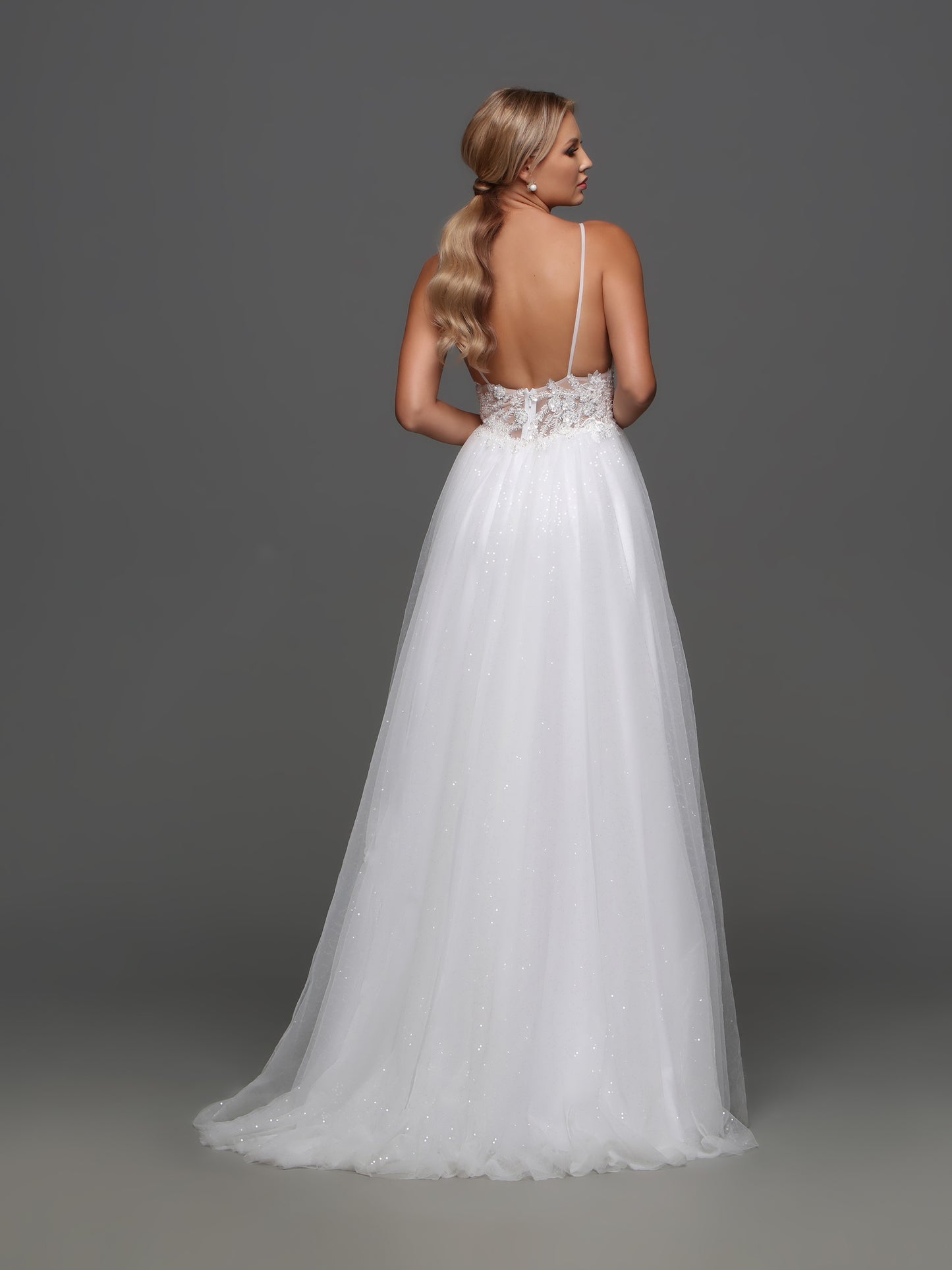 Elevate your bridal look with our Davinci Bridal F130 wedding dress. This exquisite A-line gown features intricate beading and shimmering sequins, adding a touch of glamour to your special day. The sheer bodice and V-neckline enhance your figure, while the flowing skirt creates a romantic silhouette. Be a vision of luxury and sophistication on your wedding day. Softly elegant, this A-line wedding gown has a ruched bustline and a wide sheer waistband with beaded applique. The full tulle skirt gives the dress