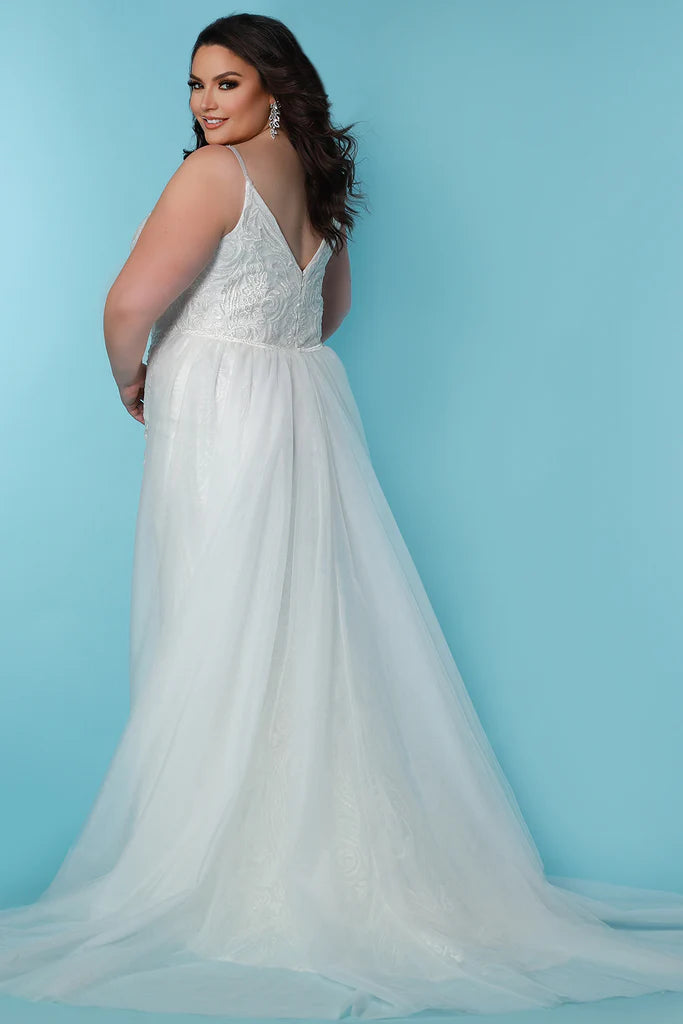 Sydneys Coset SC5287 Jolene Plus Size Bridal Dress. The Sydneys Coset SC5287 Jolene Plus Size Bridal Dress features an opulent, intricate bodice and cascading layers of matte chiffon on the skirt. Its timeless silhouette is cut to flatter the female form, and create an elegant statement as you take your place at the altar. This exquisite dress is designed exclusively for the plus size bride and is sure to make a lasting impression on your special day.