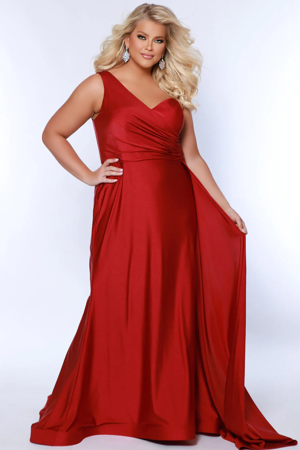 Experience elegance and glamour in the SC7377 gown from Sydneys Closet. This A-line over skirt dress features a one shoulder strap, perfect for your next special event or formal occasion. The full train adds a beautiful and regal finish to the look. Plus size available for up to size 24. Get ready to be the woman who turns heads at Prom 2024 or any special occasion evening event in the Simple and Sophisticated formal dress designed by Sydney's Closet.