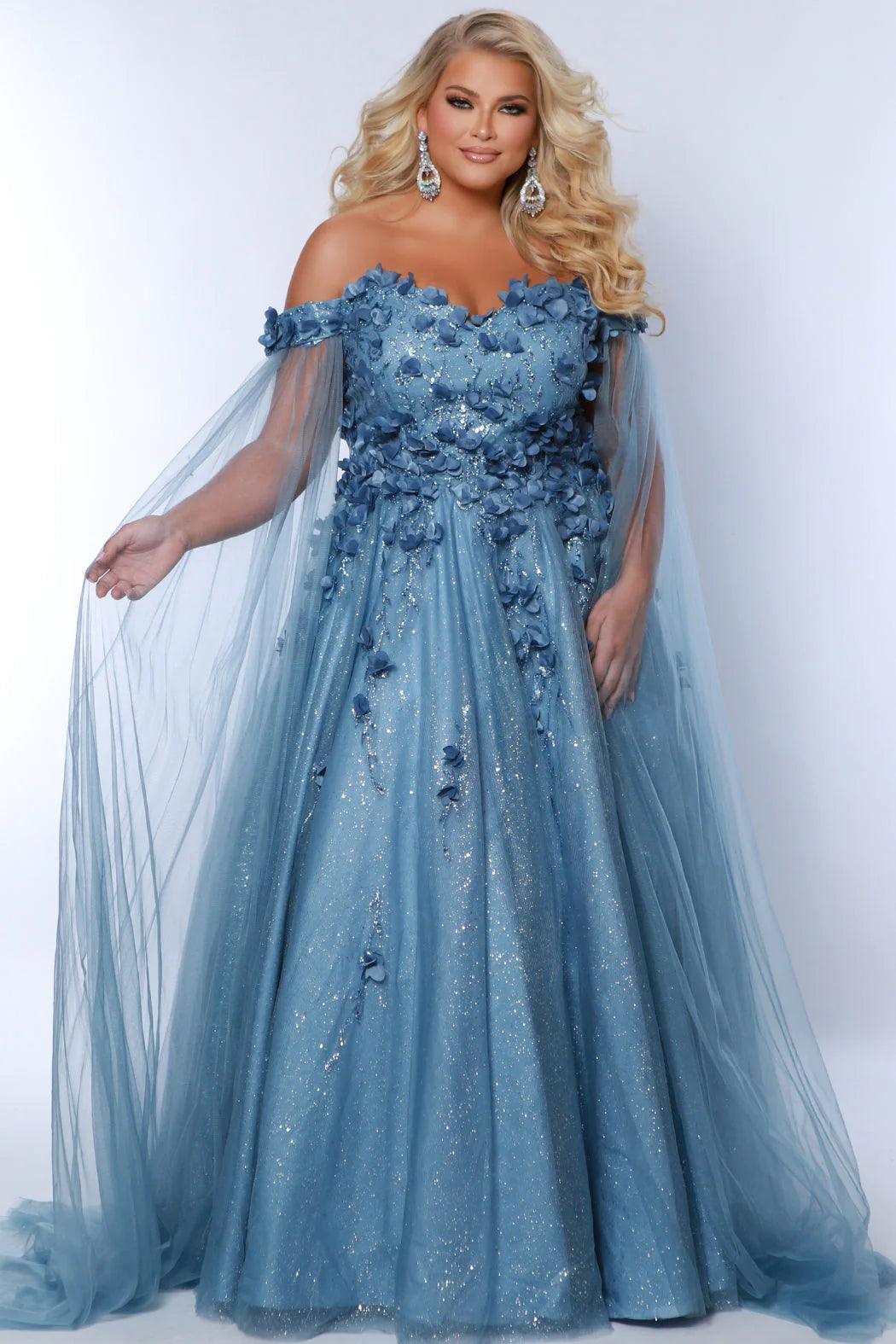 This glamorous Sydneys Closets SC7379 prom dress features an off-shoulder, sweetheart neckline and a fitted silhouette adorned with 3D floral details. The elegant design is perfect for a formal occasion such as a prom, pageant, or wedding. Plus size options are available for an ideal fit. Look and feel  like royalty at Prom 2024 or any formal ball when you opt to be lady who wears our "Dream On" gown.