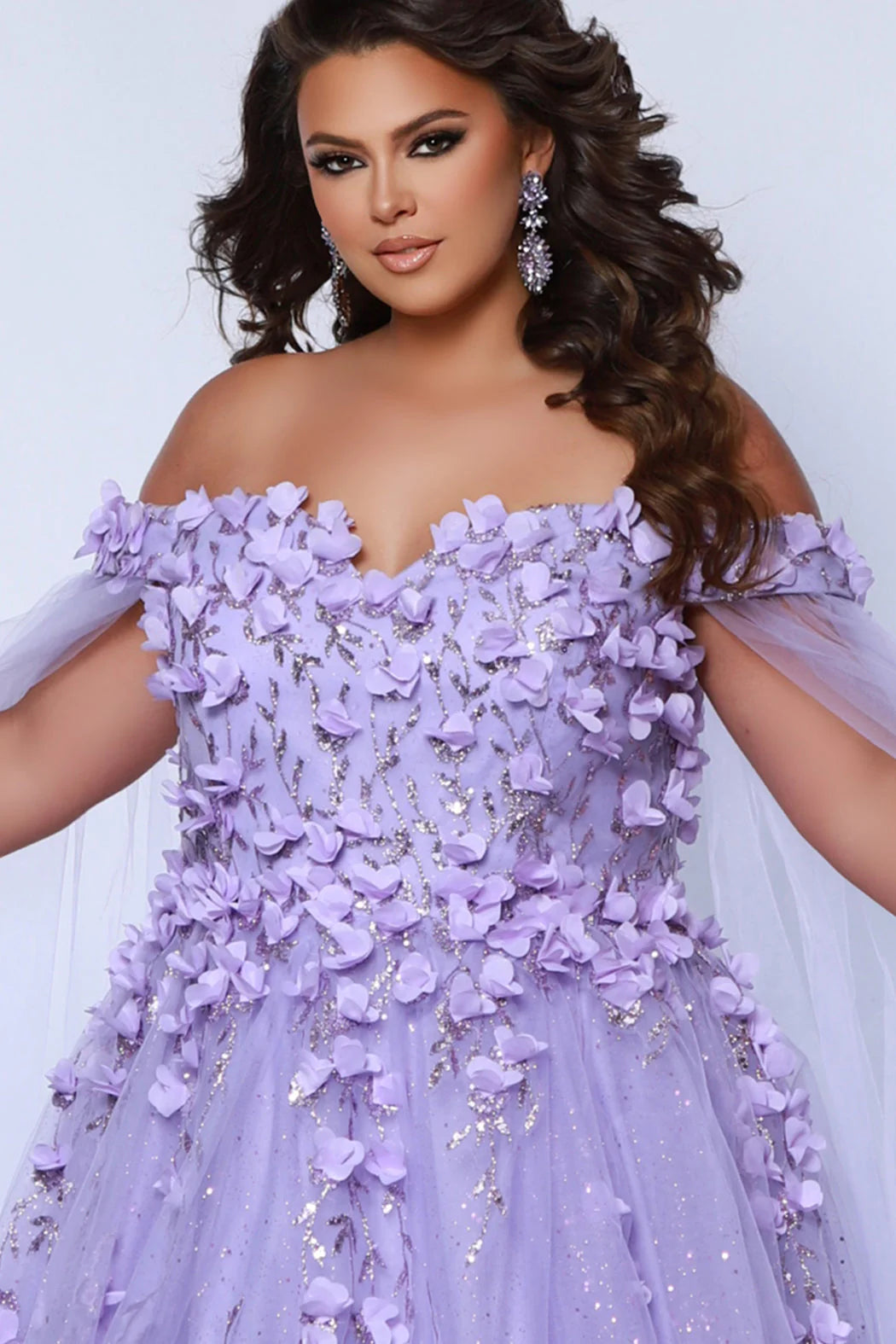 This glamorous Sydneys Closets SC7379 prom dress features an off-shoulder, sweetheart neckline and a fitted silhouette adorned with 3D floral details. The elegant design is perfect for a formal occasion such as a prom, pageant, or wedding. Plus size options are available for an ideal fit. Look and feel  like royalty at Prom 2024 or any formal ball when you opt to be lady who wears our "Dream On" gown.