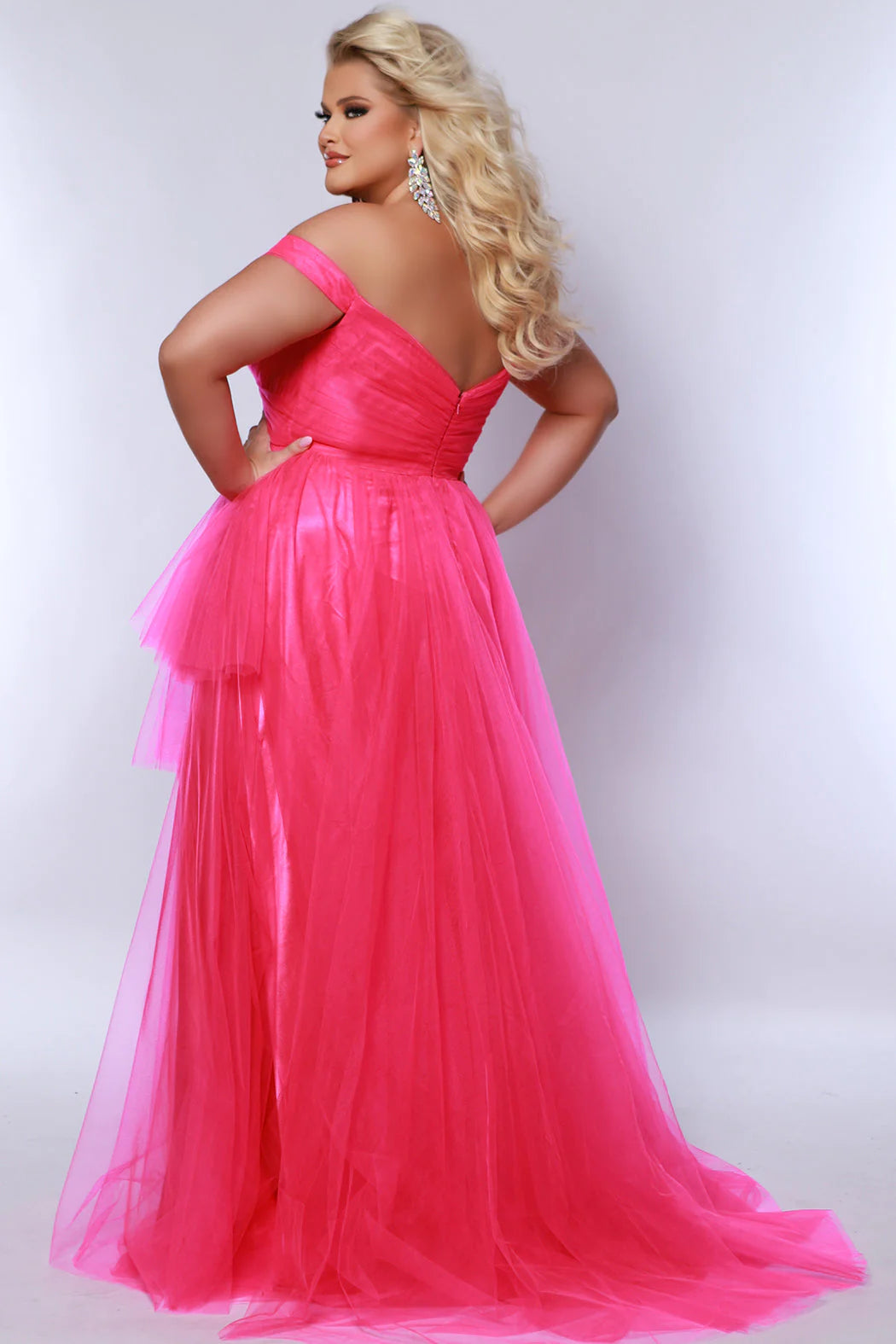 The Sydneys Closet SC7388 Long Prom Dress is a stylish A-Line design featuring an off-shoulder neckline and a 3-tier asymmetrical skirt. The plus size formal gown is a perfect choice for any pageant or other special occasion. Look fabulous no matter what your special occasion when you wear this showstopping  high-low formal dress in bold tulle fabric.