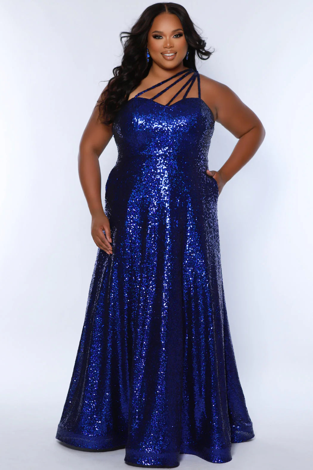 Elevate your look in Sydneys Closet SC7389 Long Prom Dress. This plus size sequin gown features an off-shoulder neckline, A-line silhouette, and pockets for added convenience. Perfect for formal occasions, this dress ensures you'll make a stunning entrance. Be the glamour Queen at Prom 2024 or any formal gala when you sparkle in our 1-shoulder sequin plus size evening dress. 