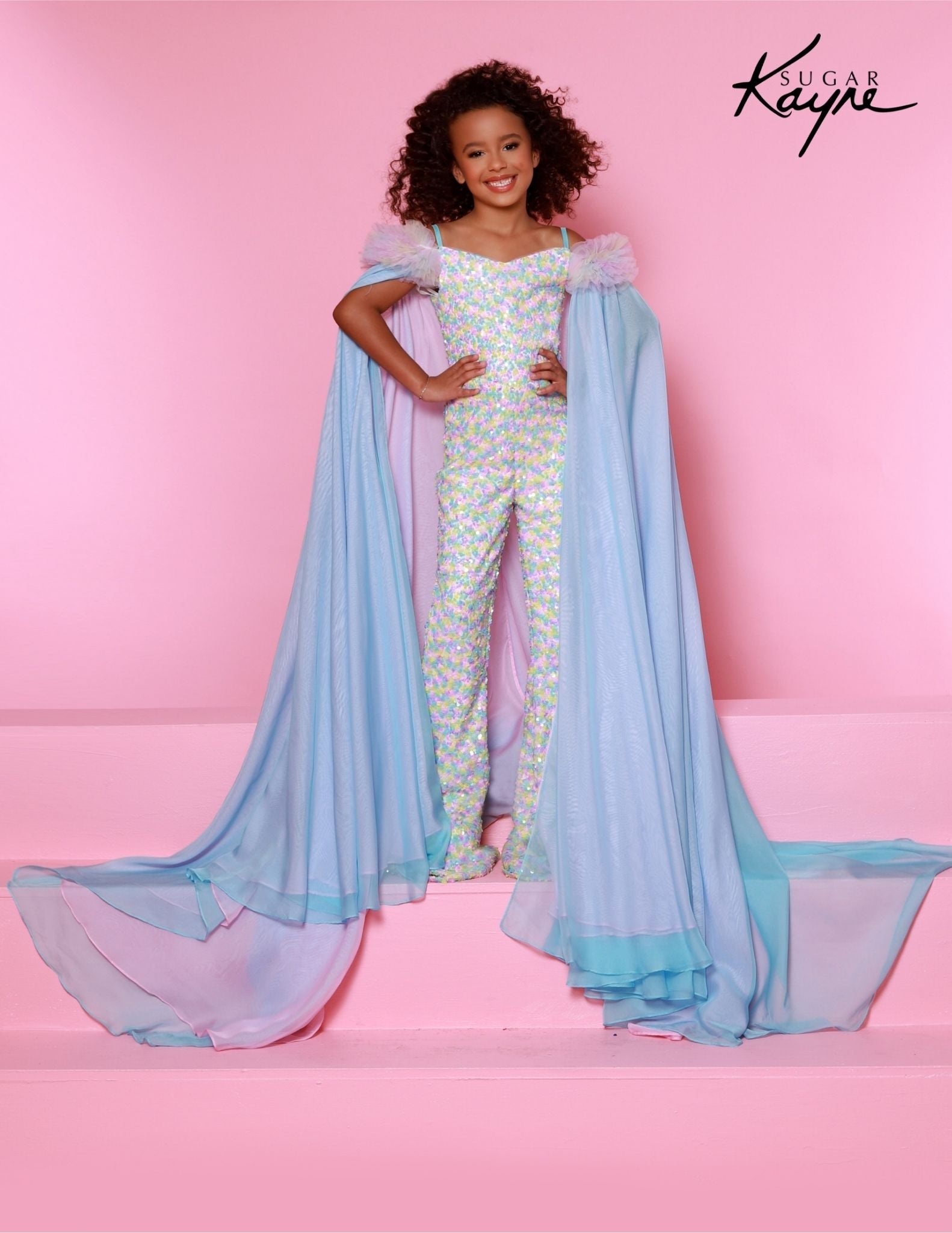 The Sugar Kayne C341 Jumpsuit is the perfect choice for your little princess. This fashionable, comfortable outfit features an all-over sequin design, ruffle sleeves and matching cape for a unique look. Perfect for clinics, pageants and any special occasion. Experience the shimmer sensation in our Sequin Power mesh Jumpsuit and matching cape! The sequined brilliance and ruffles on the shoulders create a look that's enchanting and show-stopping!