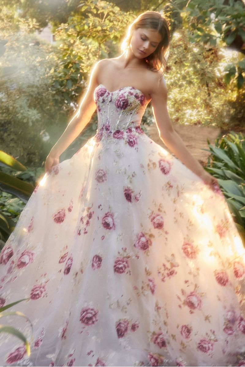 Elevate your formal attire with the Andrea & Leo Couture A1133 Floral Print A Line Prom Dress. The crystal embellished bodice adds a touch of glamour to the classic floral print, while the puff sleeves and sheer corset exude elegance. Perfect for any special occasion, this dress combines style and sophistication in one stunning design. This strapless organza peony print ball gown is a breathtaking and romantic choice for any fairytale garden. 