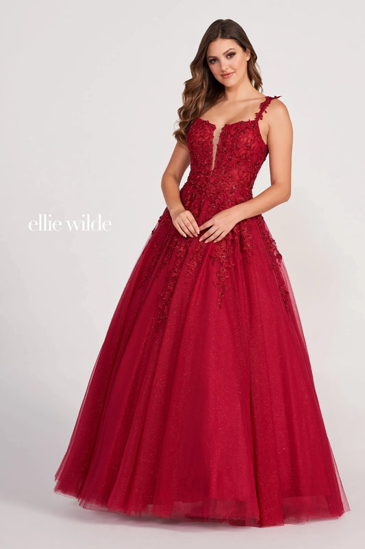 Introducing the Ellie Wilde EW120014 Long Sheer Lace Shimmer Ballgown. This sophisticated formal gown features a sheer bodice with tulle and lace appliqué, an A-line silhouette, plunging V-neckline and natural waist for a flattering fit. The skirt flows to the floor for an airy and graceful look. Make a lasting impression at your prom or special occasion.  Sizes: 00-24  Colors: PERIWINKLE, LAVENDER, RED, ROSE QUARTZ, ROYAL BLUE, WINE, TEAL, WHITE, EMERALD, NAVY BLUE, BLACK, PEONY