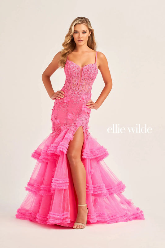 Be the star of the night in this Ellie Wilde EW35050 prom dress. The sheer lace corset with 3D dimensional appliques creates a flattering silhouette while the Tiered Tulle pleated ruffle layered trumpet skirt features a slit and shimmer fabric add a touch of glamour. The pleated mermaid skirt and slit offer both elegance and comfort.  Sizes: 00-16  Colors: OCEAN BLUE, LIGHT BLUE, HOT PINK