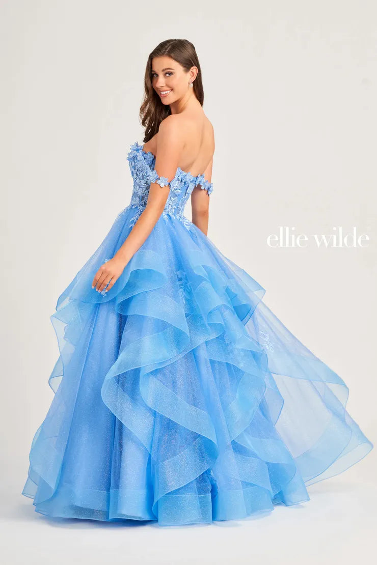 Make a statement in the Ellie Wilde EW35084 prom dress. Featuring an off-the-shoulder top, shimmer sequin lace and ruffle detail, the dress offers a timeless and sophisticated look perfect for the big night. Keep it classic in this classic formal gown.  Sizes: 00-24  Colors: EMERALD, ROYAL BLUE, TEAL, HOT PINK, BLUEBELL