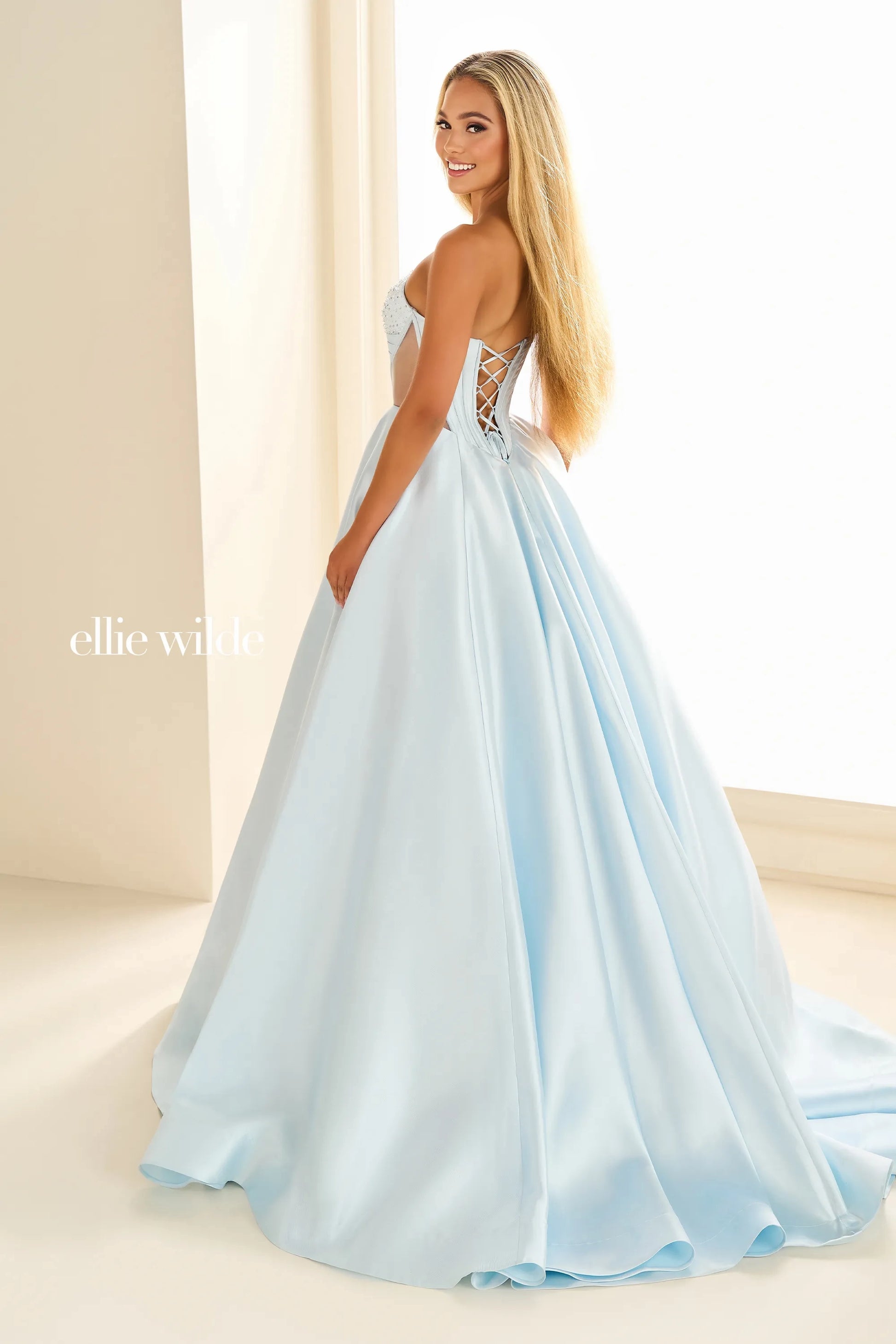 This Ellie Wilde EW36025 prom dress features a stunning A-line silhouette with sheer ballgown detailing and a corset back for a perfect fit. The dress also includes convenient pockets and cut-out design, making it both fashionable and functional for any pageant or formal event.