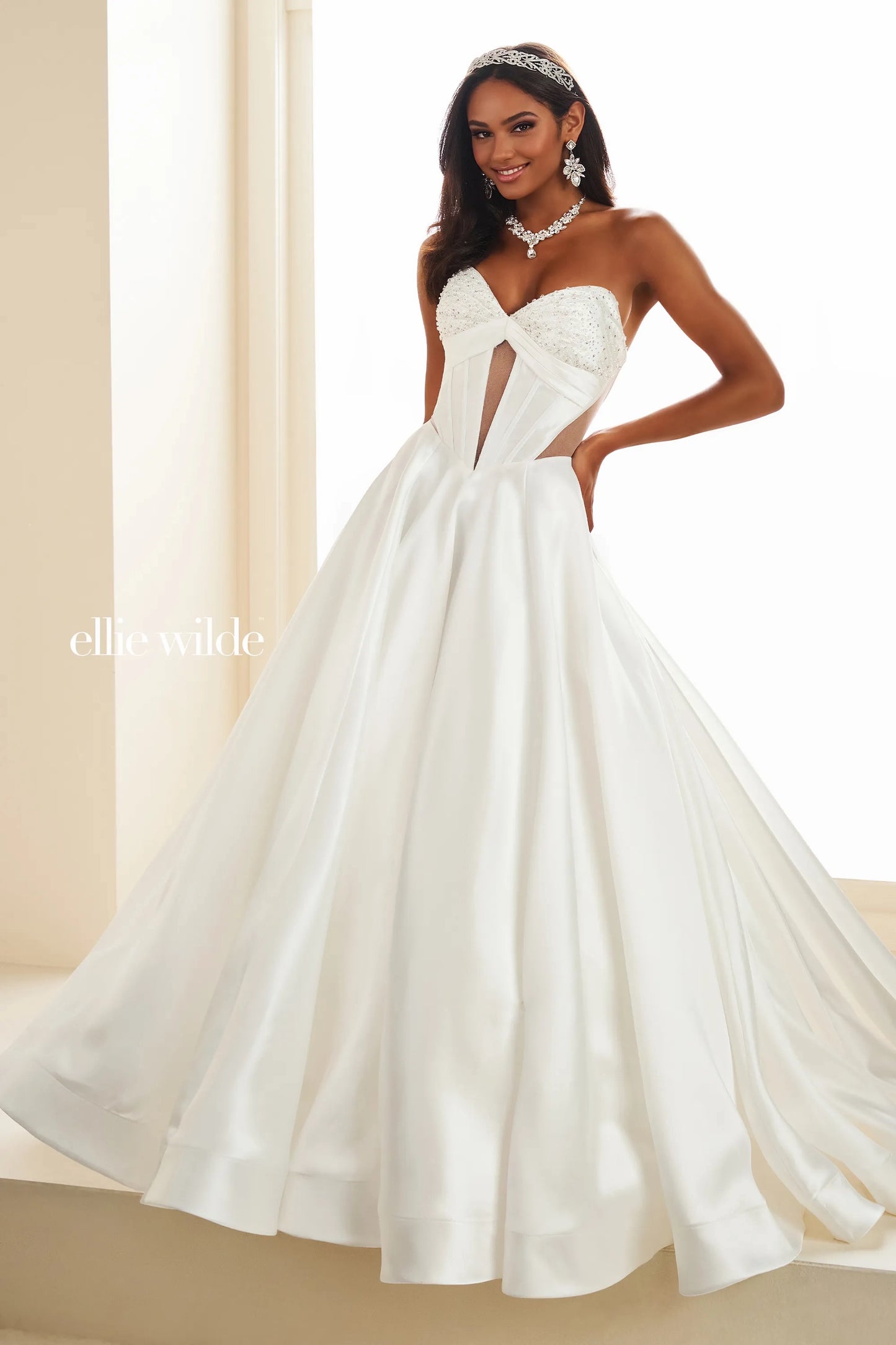 This Ellie Wilde EW36025 prom dress features a stunning A-line silhouette with sheer ballgown detailing and a corset back for a perfect fit. The dress also includes convenient pockets and cut-out design, making it both fashionable and functional for any pageant or formal event.