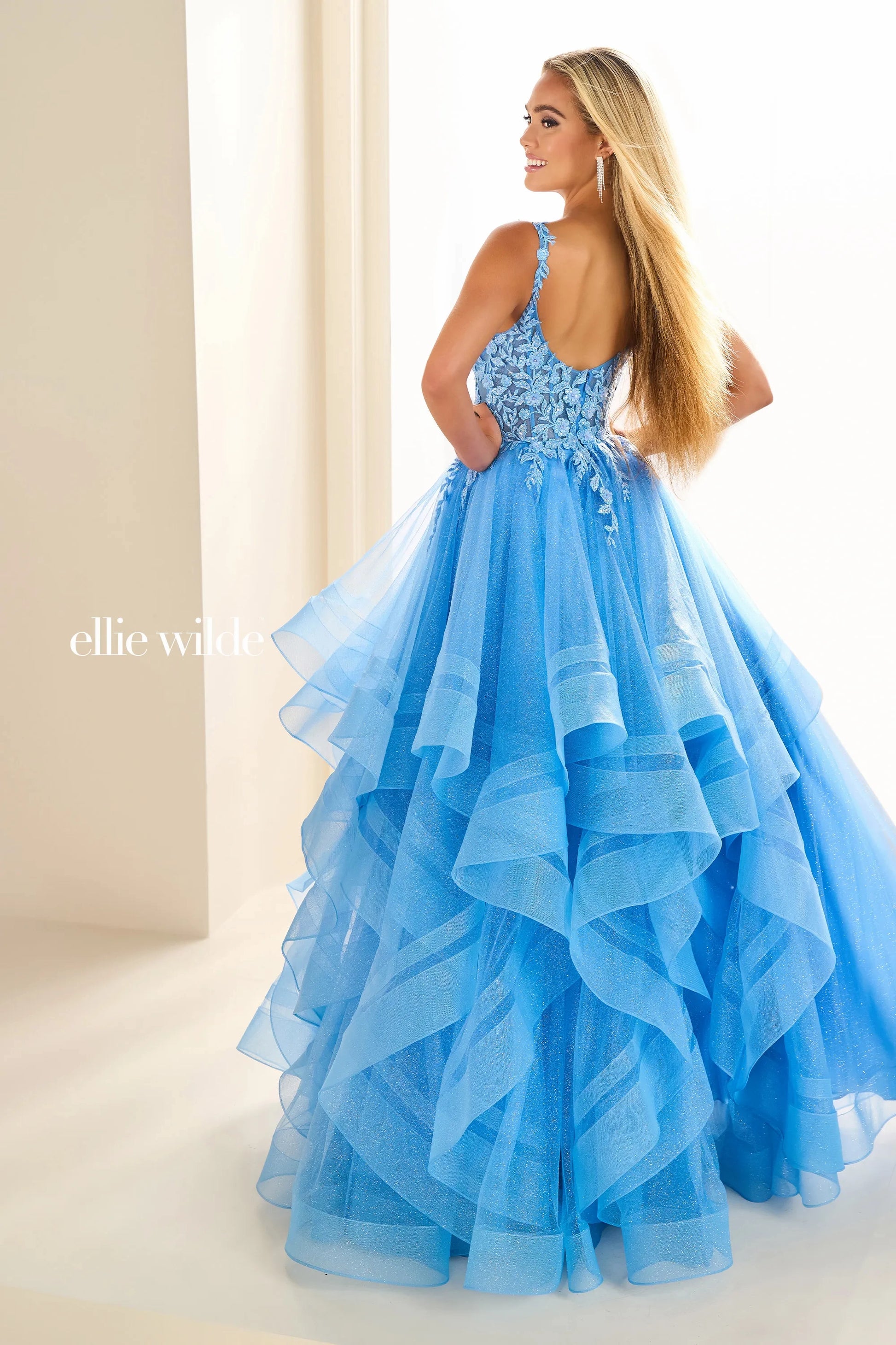 Expertly crafted by Ellie Wilde, the EW36035 dress boasts a sheer lace shimmer, ruffle details, and a corset-style bodice. Completed with a sequin layer for added sparkle, this ballgown will make you stand out at any prom or formal event. Elevate your style and confidence with this stunning dress.