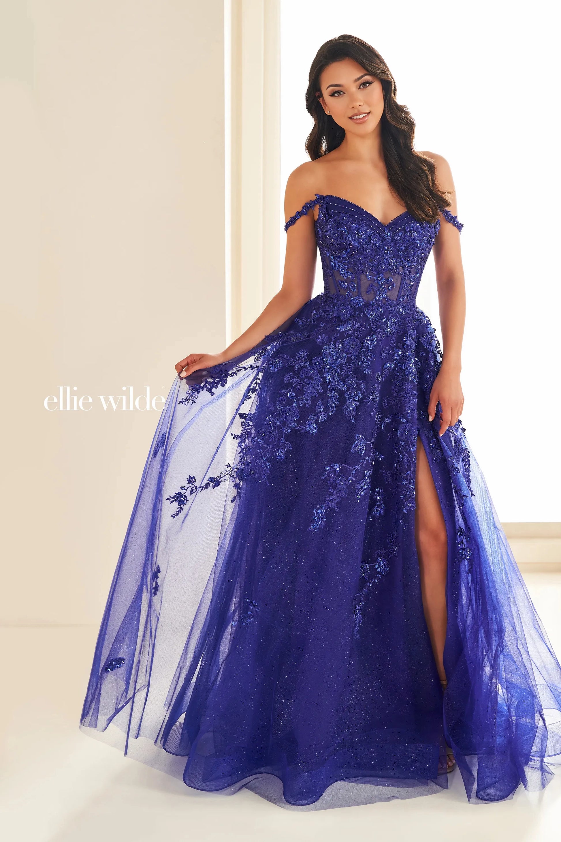 Experience the ultimate in elegance and glamour with the Ellie Wilde EW36204 prom dress. This stunning gown features a sequin lace corset bodice, sheer detailing, and an alluring slit. The off-the-shoulder neckline is adorned with intricate beading, adding a touch of sparkle to this already exquisite dress. Embody sophistication and grace on your special night.&nbsp;