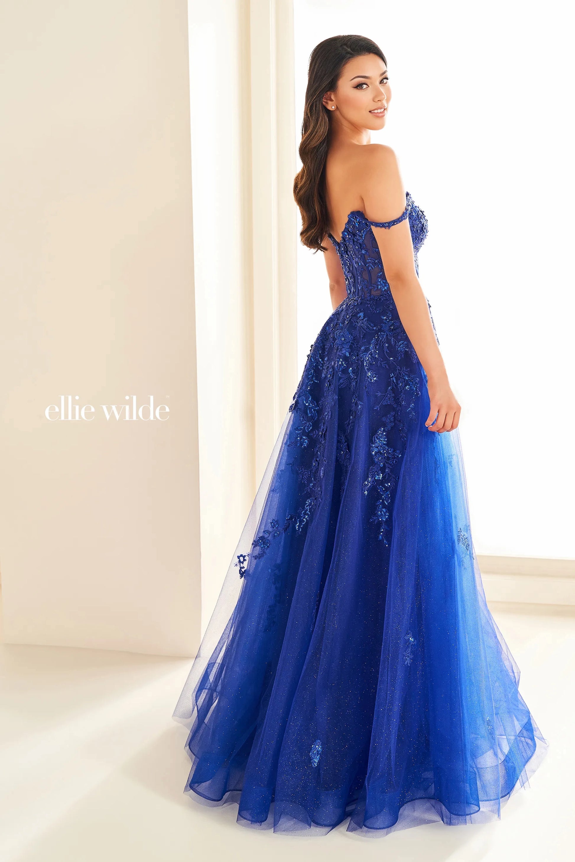 Experience the ultimate in elegance and glamour with the Ellie Wilde EW36204 prom dress. This stunning gown features a sequin lace corset bodice, sheer detailing, and an alluring slit. The off-the-shoulder neckline is adorned with intricate beading, adding a touch of sparkle to this already exquisite dress. Embody sophistication and grace on your special night.&nbsp;