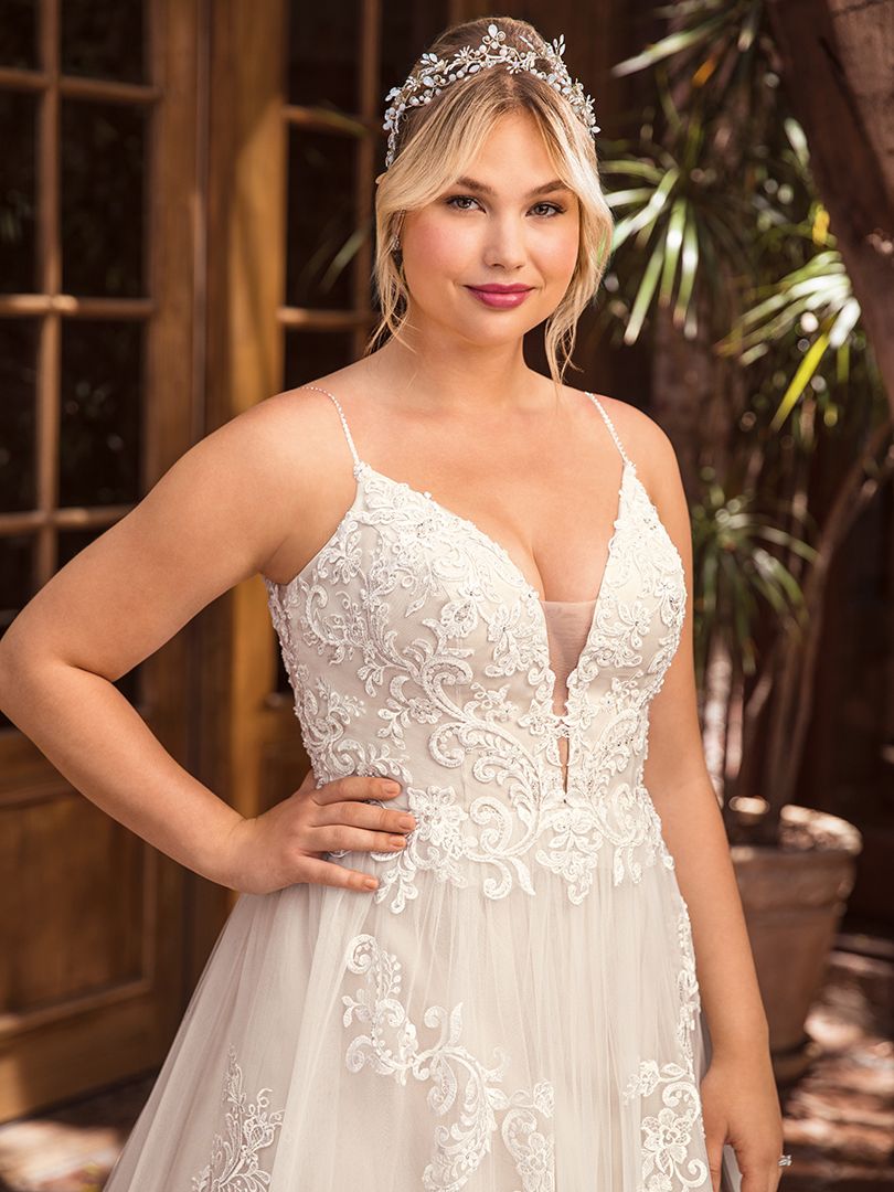 Casablanca Beloved STYLE BL286 DELILAH Other-worldly grace surrounds Delilah, swimming in sateen satin and tulle. Lace appliques cover the bodice and cascade down the flowing skirt of this bohemian wedding gown from Beloved by Casablanca Bridal. Spaghetti straps and a plunging neckline add a seductive touch, transitioning into an alluring illusion lace back. Subtle silver beading catches the light, while a matching veil finishes off this modern boho gown with a glimmer!