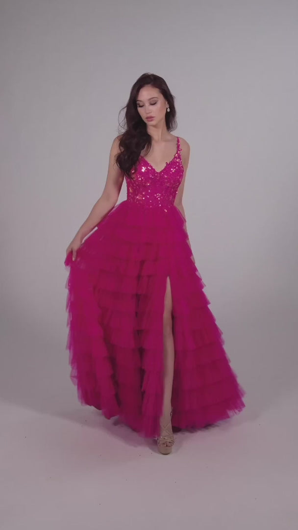 This Ellie Wilde EW35059 prom dress exudes elegance and glamour. The long tulle layers, A-line silhouette, and lace Sequin corset enhance your natural curves, while the maxi slit and sequin details add a touch of sparkle. Perfect for prom or any formal event, this dress is sure to make a statement.  Sizes: 00-20  Colors: ﻿BLACK, MAGENTA, ROYAL BLUE, BARBIE PINK