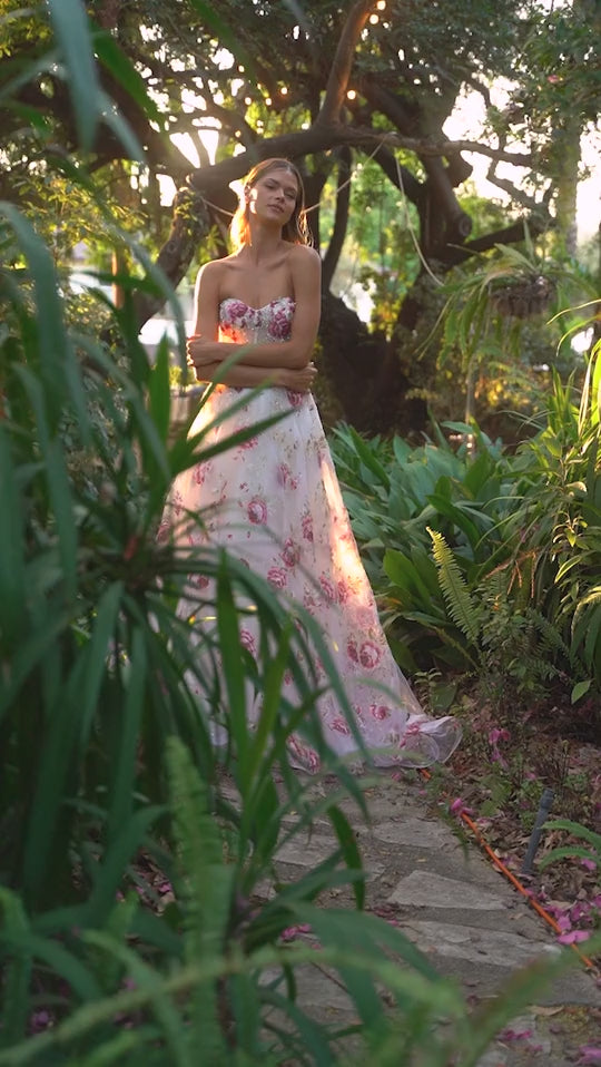 Elevate your formal attire with the Andrea & Leo Couture A1133 Floral Print A Line Prom Dress. The crystal embellished bodice adds a touch of glamour to the classic floral print, while the puff sleeves and sheer corset exude elegance. Perfect for any special occasion, this dress combines style and sophistication in one stunning design. This strapless organza peony print ball gown is a breathtaking and romantic choice for any fairytale garden. 