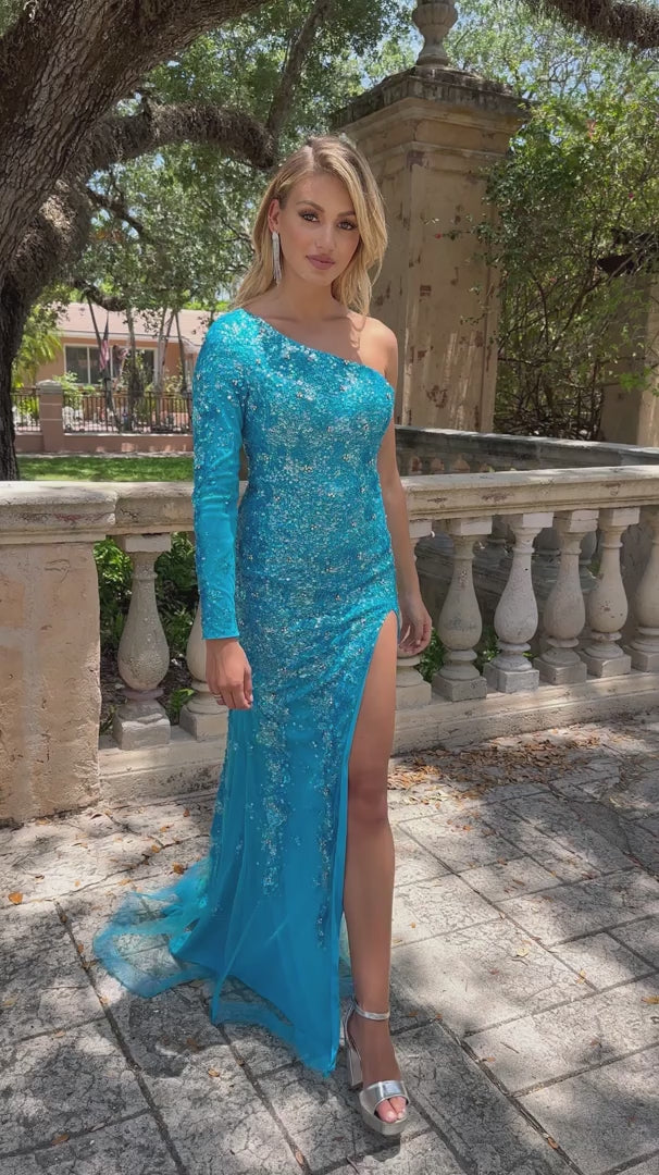 This stunning Ava Presley 28578 long prom dress features a one shoulder design with an intricate sequin pattern. The high slit and cape sleeve add a touch of elegance to this formal gown, making it perfect for any pageant or special occasion. Make a statement and stand out in style with Ava Presley.