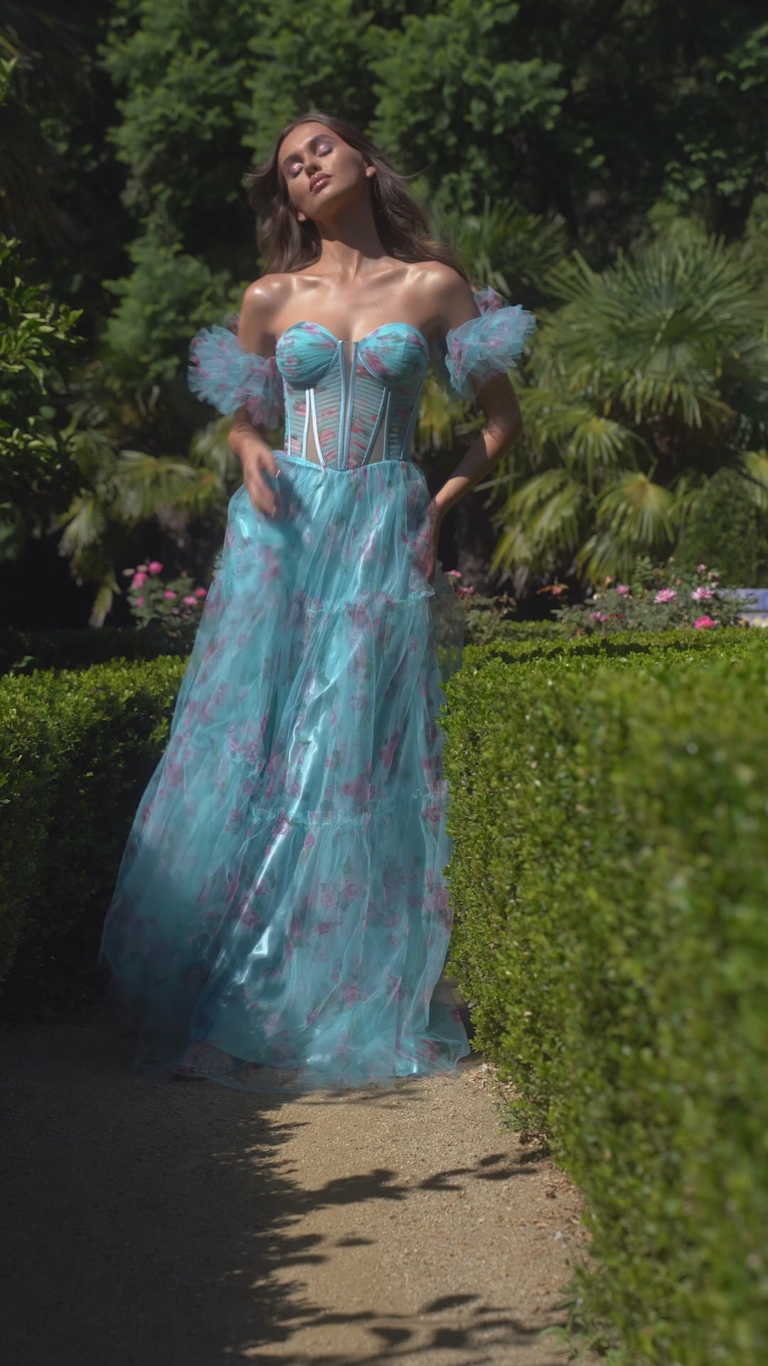 This stunning prom dress by Andrea & Leo Couture features a beautiful floral print, a sheer corset bodice for a touch of sensuality, and a flattering A-line silhouette. The puff sleeves and V-neckline add a touch of romance to this elegant design. Perfect for any special occasion, this dress is sure to make you feel confident and beautiful. Step into a dream with this off-the-shoulder floral printed tulle A-line dress—a whimsical ode to the enchanting world of cottage core