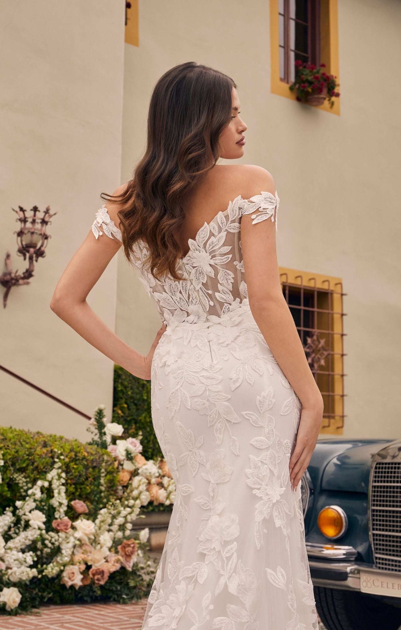 Casablanca Bridal 2541 Augustine A-Line Off The Shoulder 3D Floral Appliques Sheer Corset Train Slit Wedding Gown. Stretch georgette & stretch chiffon lining with beaded & sequined floral lace & 3D floral appliques, all come together to form a glamourous off-the-shoulder bodice with wide lace straps and a sweetheart neckline. A flattering high waist tops the cascading fit and flare skirt with a tigh high slit that ends with a court-length train at back.