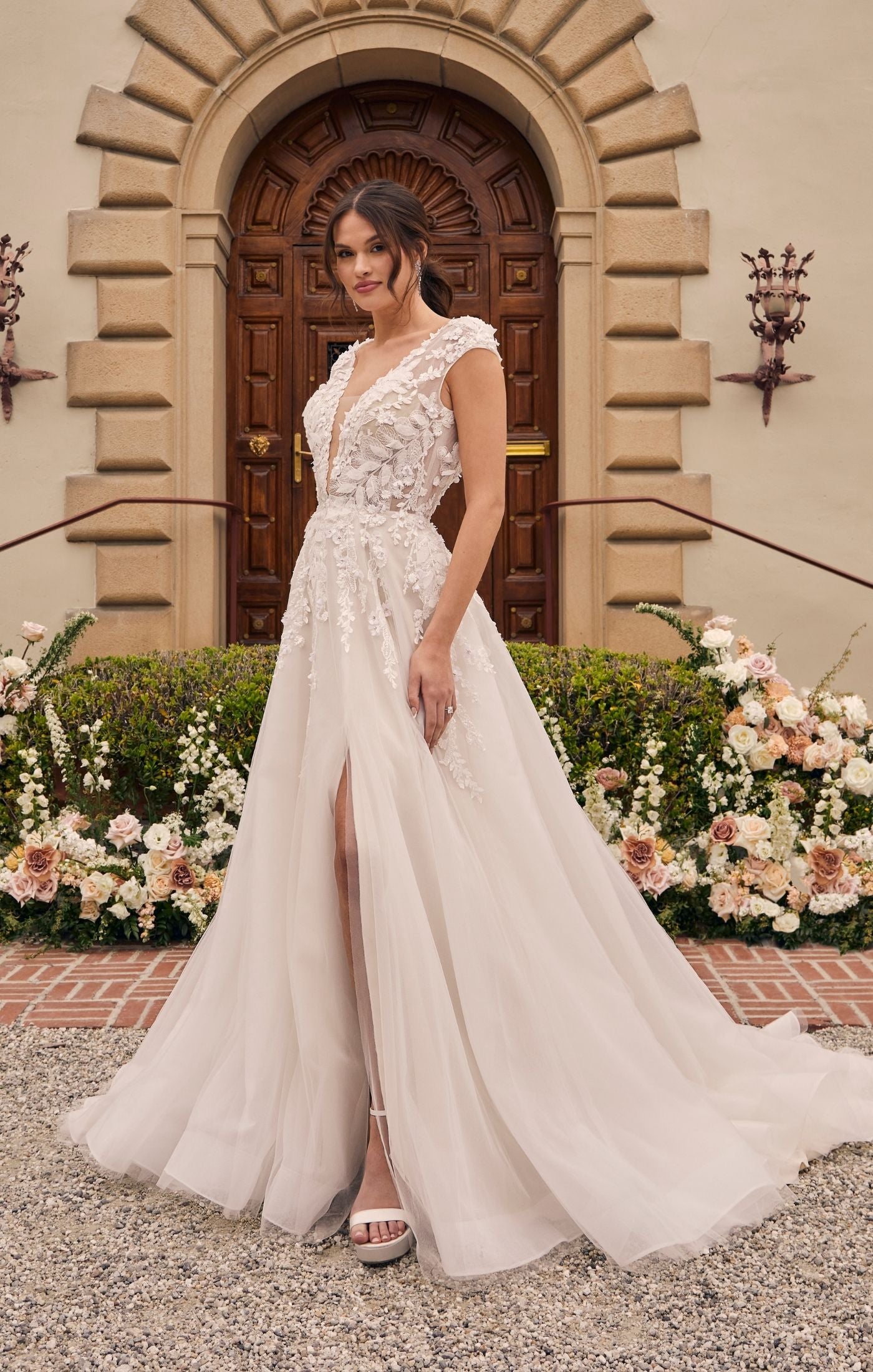 Casablanca Bridal 2551 A-Line Ballgown Cap Sleeves Plunging Neckline Lace Long Wedding gown. Style 2551 Mirabelle, an A-Line silhouette that embraces your natural curves while providing a flattering and comfortable fit. Adorned with delicate floral vine lace appliques, embellished with sequins and beading, this dress exudes an ethereal charm that will leave everyone in awe. romance and allure