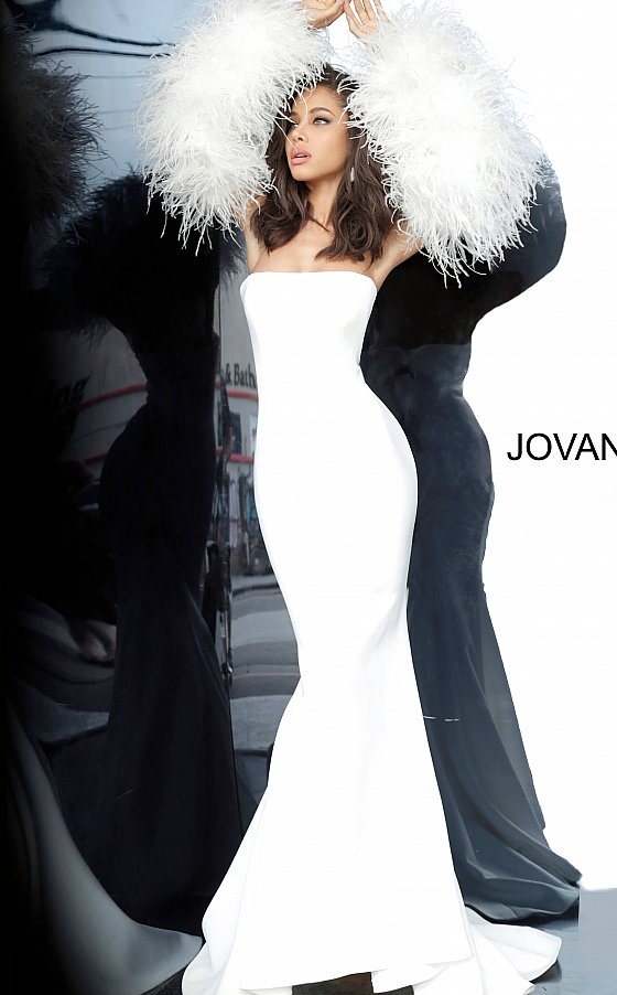 Jovani 1226 is a Long Fitted Mermaid Scuba Formal Evening Gown. This Straight neckline with Long Off the Shoulder Feather Sleeves. This Fit & Flare Wedding Dress Features a Lush Sweeping train. Great Red Carpet or formal event gown. Great for a wedding guest dress or mother of the bride gown. Stretch scuba fabric, form fitting silhouette, floor length with train, strapless bodice, straight neckline, ostrich feather sleeves. Available Sizes: 00-24  Available Colors: black, blush, white, white/black